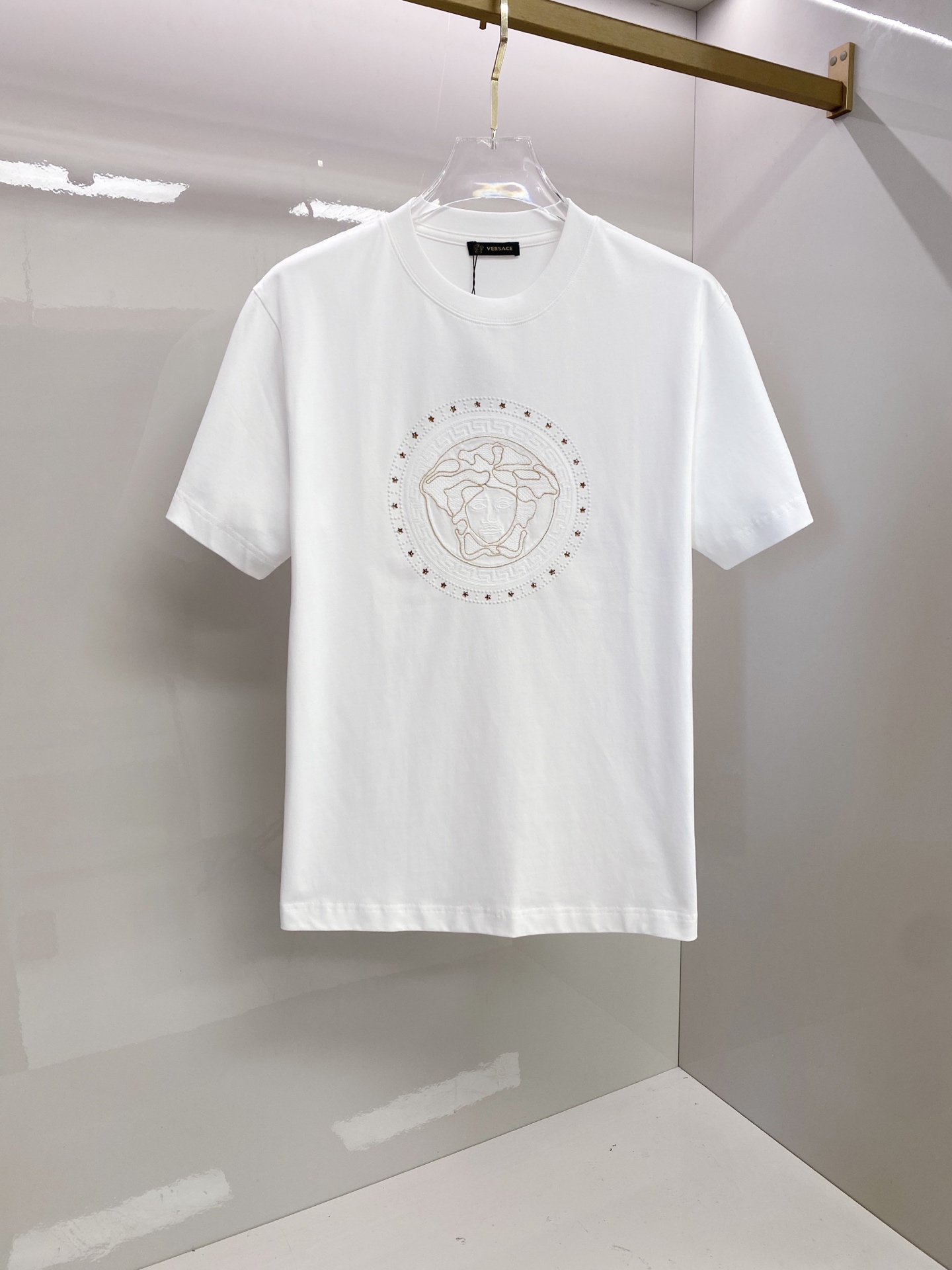 NO:835129,Versace 2026 spring and summer new style Versace Medusa embroidered short-sleeved T-shirt, the brand's iconic Medusa head embroidery is matched with a Greek key border, which has a kingly aura. The high-count cotton fabric is draped and crisp, and the three-dimensional embroidery technology is exquisite and full, showing the brand recognition in a low-key manner. The slightly loose shoulder cut is modified to modify the shoulder line, and the black/white two-tone color is suitable for all spring and summer outfits, and it is easy to achieve advanced casual style.  Size S-XXL,,versace,versace,T-shirt,tees,t-shirt,19860909范思哲 2026春夏新款 Versace美杜莎刺绣短袖T恤,品牌标志性美杜莎头像刺绣搭配希腊回纹边框,自带王者气场 高支棉面料垂坠挺括,立体刺绣工艺精致饱满,低调中尽显品牌辨识度 微宽松落肩剪裁修饰肩线,黑/白双色适配所有春夏穿搭,轻松拿捏高级休闲风 码数S-XXL,,versace,versace,T-shirt,tees，t-shirt,,Men's clothing