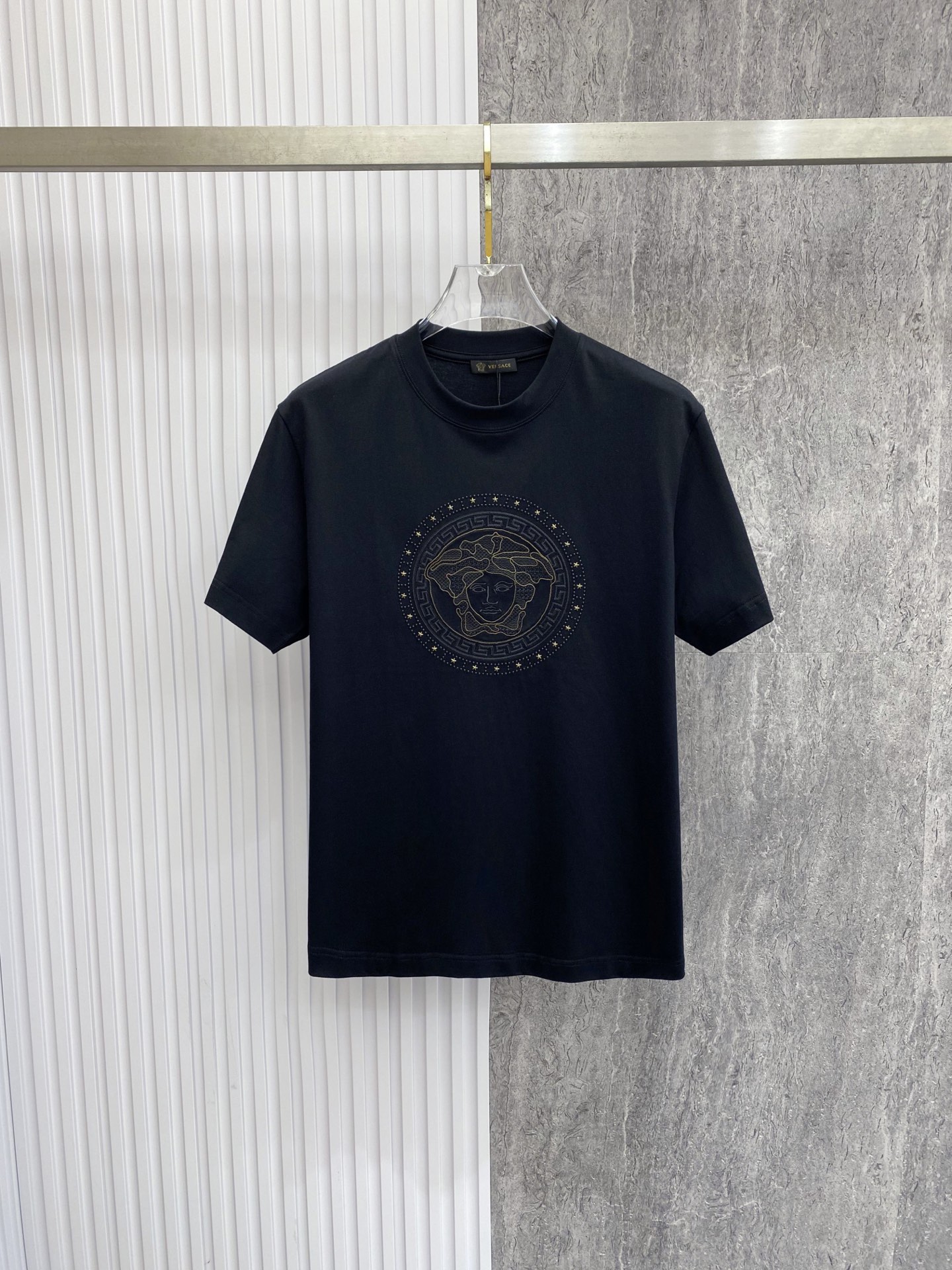 NO:842784,Versace 2026 spring and summer new style Versace Medusa embroidered short-sleeved T-shirt, the brand's iconic Medusa head embroidery is matched with a Greek key border, which has a kingly aura. The high-count cotton fabric is draped and crisp, and the three-dimensional embroidery technology is exquisite and full, showing the brand recognition in a low-key manner. The slightly loose shoulder cut is modified to modify the shoulder line, and the black/white two-tone color is suitable for all spring and summer outfits, and it is easy to achieve advanced casual style.  Size S-XXL,,versace,versace,T-shirt,tees,t-shirt,19860909范思哲 2026春夏新款 Versace美杜莎刺绣短袖T恤,品牌标志性美杜莎头像刺绣搭配希腊回纹边框,自带王者气场 高支棉面料垂坠挺括,立体刺绣工艺精致饱满,低调中尽显品牌辨识度 微宽松落肩剪裁修饰肩线,黑/白双色适配所有春夏穿搭,轻松拿捏高级休闲风 码数S-XXL,,versace,versace,T-shirt,tees，t-shirt,,Men's clothing