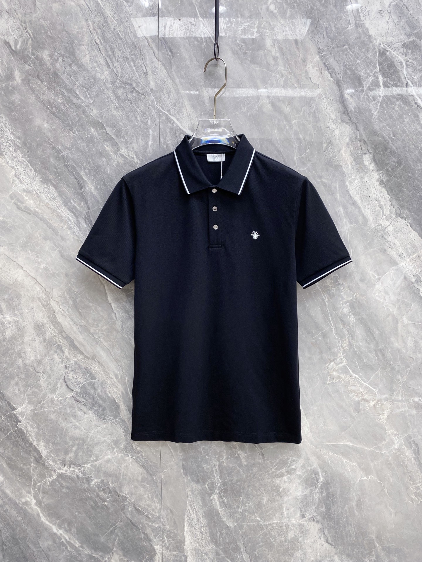 NO:861120,Dior Dior 2026ss spring and summer new style | Dior bee embroidered Polo shirt  The high-density breathable piqué cotton fabric is selected, with a delicate touch, and the upper body is dry and not sweaty, which is perfect for the hot weather in spring and summer. The contrasting edge collar and cuff design are neat and stylish; the delicate bee embroidery on the chest low-key highlights the brand recognition. The black and white two-color classic and versatile, whether it is commuting business or daily leisure, you can easily create a simple and high-end urban outfit, which is a must-have for the spring and summer wardrobe. Color black white  Code number 48-56,,dior,dior,19860909Dior 迪奥 2026ss春夏新款 | Dior 蜜蜂刺绣Polo衫 甄选高密透气珠地棉面料,触感细腻,上身干爽不闷汗,完美适配春夏高温天气.撞色包边领+袖口设计,利落有型；胸口精致小蜜蜂刺绣,低调彰显品牌辨识度.黑白双色经典百搭,无论是通勤商务还是日常休闲,都能轻松打造简约高级的都市穿搭,是春夏衣橱的刚需款. 颜色黑色 白色 码数48-56,,dior,dior,,Men's clothing