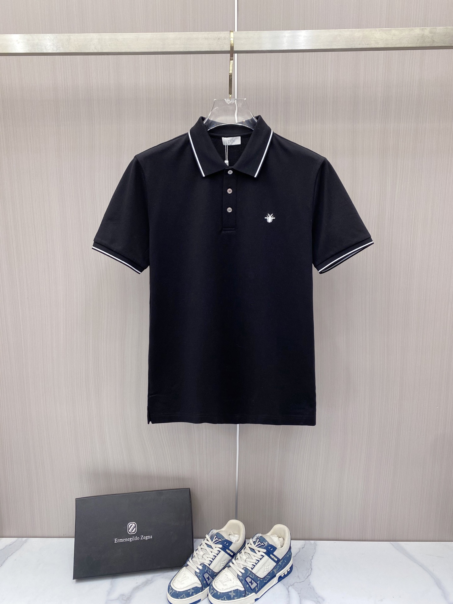 NO:848761,Dior Dior 2026ss spring and summer new style | Dior bee embroidered Polo shirt  The high-density breathable piqué cotton fabric is selected, with a delicate touch, and the upper body is dry and not sweaty, which is perfect for the hot weather in spring and summer. The contrasting edge collar and cuff design are neat and stylish; the delicate bee embroidery on the chest low-key highlights the brand recognition. The black and white two-color classic and versatile, whether it is commuting business or daily leisure, you can easily create a simple and high-end urban outfit, which is a must-have for the spring and summer wardrobe. Color black white  Code number 48-56,,dior,dior,19860909Dior 迪奥 2026ss春夏新款 | Dior 蜜蜂刺绣Polo衫 甄选高密透气珠地棉面料,触感细腻,上身干爽不闷汗,完美适配春夏高温天气.撞色包边领+袖口设计,利落有型；胸口精致小蜜蜂刺绣,低调彰显品牌辨识度.黑白双色经典百搭,无论是通勤商务还是日常休闲,都能轻松打造简约高级的都市穿搭,是春夏衣橱的刚需款. 颜色黑色 白色 码数48-56,,dior,dior,,Men's clothing