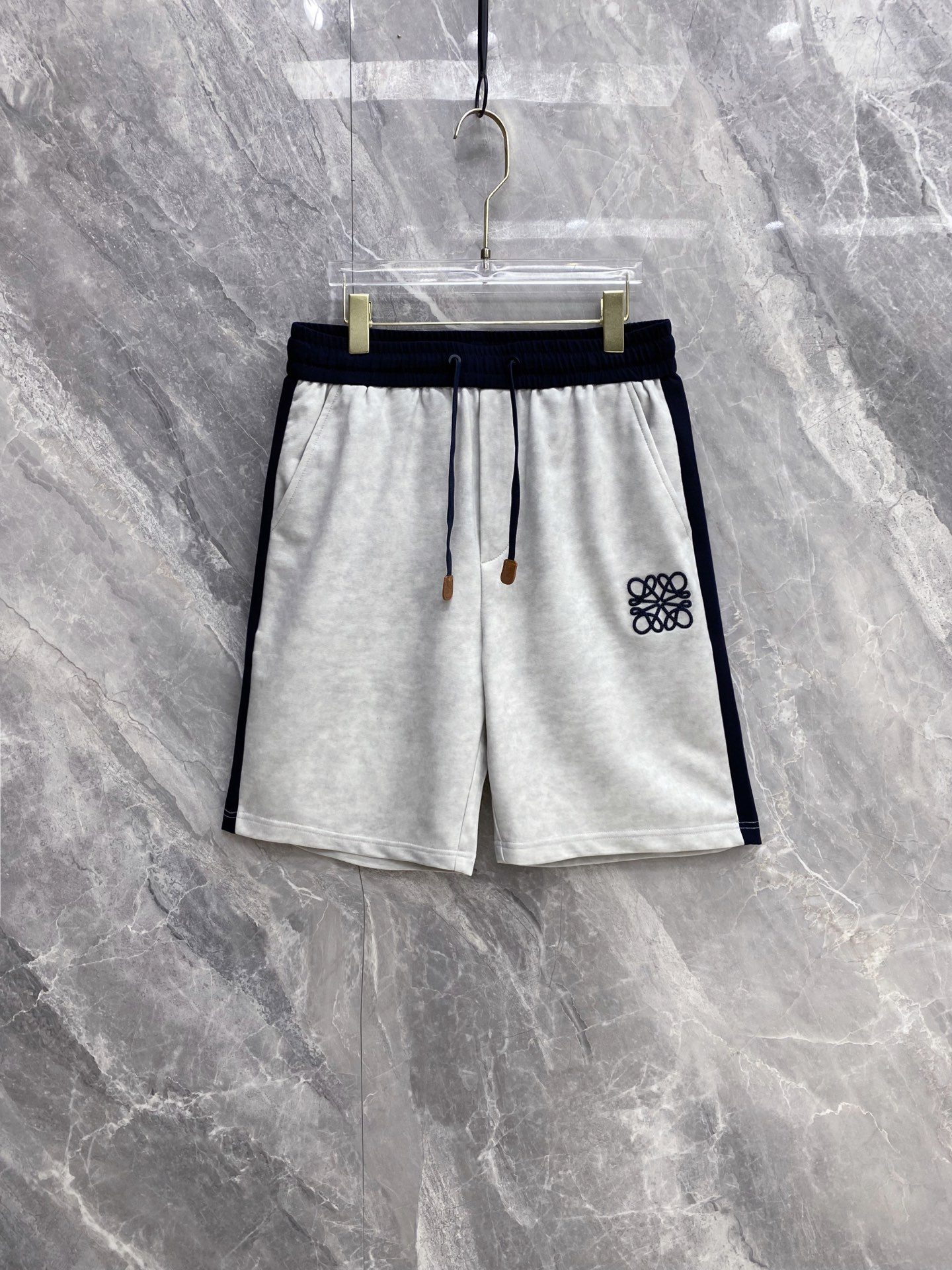NO:860963,| LOEWE 2026 Spring and Summer New Style Contrast Color Ribbon Casual Sweatpants, a must-have spring and summer item with a lazy old-money style, side contrast ribbon + iconic Anagram embroidery, complete the effortless sense of luxury. Selected high-weight breathable terry fabric, the upper body is soft and skin-friendly, draped and stylish without being sweaty, and the loose cut hides the flesh and is neat  The elastic drawstring waistband with genuine leather decorative details has a full texture, adapts to a variety of body shapes, and has zero constraints for daily wear. Practical pockets on both sides take into account both appearance and practicality, making it easy to control casual, sophisticated, and commuting styles. It can match your wardrobe throughout the summer. Size 48~56,,loewe,loewe,19860909| LOEWE 罗意威 2026春夏新款 撞色织带休闲卫裤 自带慵懒老钱风的春夏刚需单品,侧边撞色织带+标志性Anagram刺绣,把不费力的高级感拉满 甄选高克重透气毛圈面料,上身软糯亲肤,垂坠有型不闷汗,宽松剪裁藏肉又利落 松紧抽绳腰头搭配真皮装饰细节,质感拉满,适配多种身形,日常穿零束缚 双侧实用口袋兼顾颜值与实用性,轻松驾驭休闲、轻熟、通勤多种风格,承包你整个夏天的衣柜搭配 码数48~56,,loewe,loewe,,Men's clothing