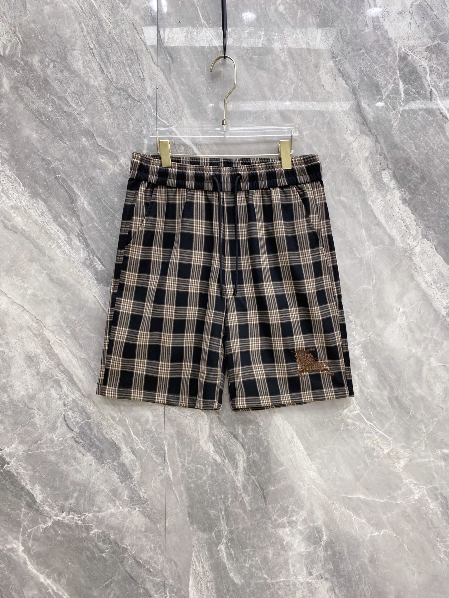 NO:911765,Burberry's 1946 spring and summer hit | Burberry plaid equestrian embroidered casual shorts. Who knows!  This is really a retro style ceiling for spring and summer!  Classic retro plaid fabric, with a British atmosphere, great breathability and drape, refreshing and not sweaty in summer. Elastic waist + drawstring design, not tight on the belly and not flattering on the figure, super easy to put on and take off, a must-have for lazy people. Equestrian knight embroidery on the trousers, exquisite and eye-catching details, low-key and brand recognition, full of retro feel. Available in two colors, both boys and girls can handle it, suitable for daily outings, vacations, and light commuting.  Code number 48-56,,burberry,burberry,shorts,19860909巴宝莉1946春夏爆款｜Burberry格纹马术刺绣休闲短裤 谁懂啊！这条真的是春夏复古风天花板！ 经典复古格纹面料,自带英伦氛围,透气垂坠感超棒,夏天穿清爽不闷汗 松紧腰+抽绳设计,不勒肚子不挑身材,穿脱超方便,懒人穿搭必备 裤脚马术骑士刺绣,细节精致耐看,低调中自带品牌辨识度,复古感拉满 两色可选,男生女生都能驾驭,日常出街、度假、轻通勤都能搭 码数48-56,,burberry,burberry,shorts,,Men's clothing
