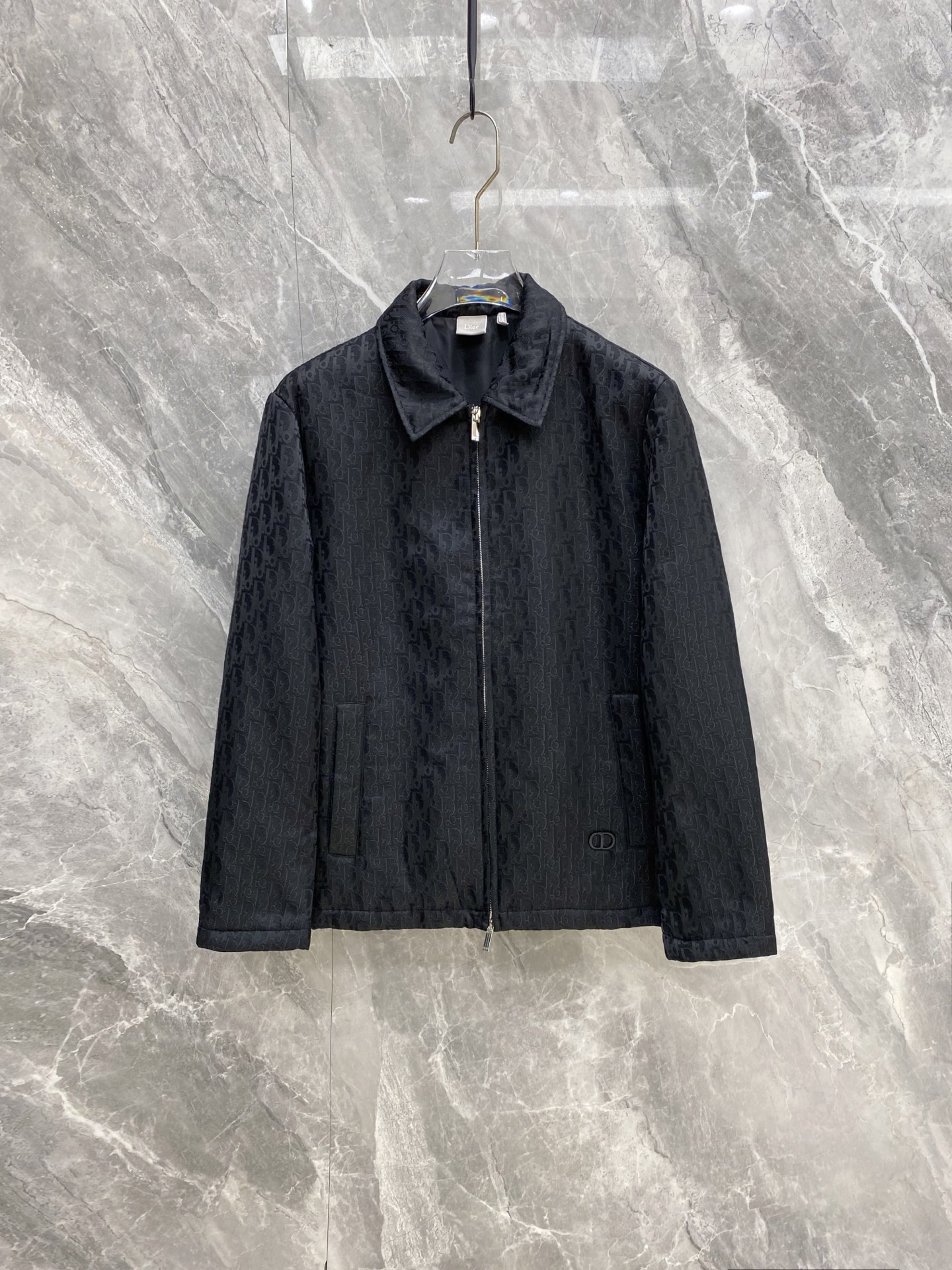NO:956569,Dior Dior 2026 autumn and winter low-key luxury commuter jacket  Smooth matte fabrics are selected, and the same color dark jacquard pattern is printed all over the body. The visual is low-key and hides the details; the thin cotton padding inside is both windproof and warm, suitable for autumn and winter temperatures. The classic lapel zipper workwear version, straight and loose tailoring weakens the shortcomings of the body; invisible pockets on both sides  To ensure practicality, the small metal mark on the hem is used as a low-key logo, without unnecessary complicated design. The pure black basic color is suitable for various inner wears such as shirts, turtleneck sweaters, and sweatshirts. It can be used for business trips and daily leisure. It is the same style for men and women. It is a must-have item for the 2026 autumn and winter minimalist high-end style.  Size M-3XL,,dior,dior,hoodie,sweatshirts,jackets & coats,jackets & coats,sweaters,shirts,19860909Dior 迪奥 2026秋冬低调轻奢通勤夹克外套 甄选顺滑哑光面料,全身同色系暗纹提花满印图案,视觉低调暗藏细节；内里薄夹棉填充,兼顾防风与保暖,适配秋冬气温.经典翻领拉链工装版型,直筒宽松剪裁弱化身材短板；两侧隐形插袋保障实用性,下摆金属小标作为低调标识,无多余繁杂设计.纯黑基础色系适配衬衫、高领毛衣、卫衣多种内搭,商务出行、日常休闲均可驾驭,男女同款,是2026秋冬极简高级风必备单品. 码数M-3XL,,dior,dior,hoodie,sweatshirts,jackets & coats,jackets & coats,sweaters,shirts,,Men's clothing