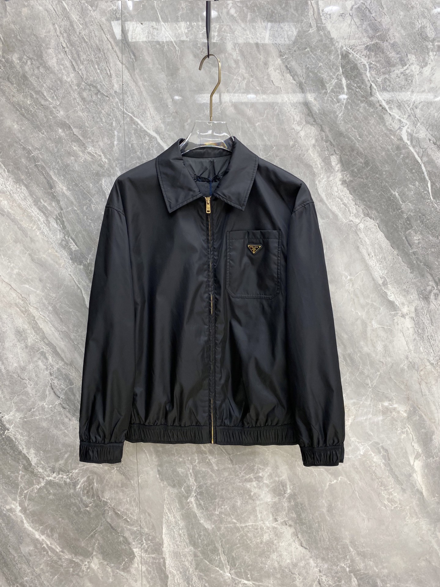 NO:956576,Prada New Products for Autumn and Winter 2026｜Prada Regenerated Nylon Lapel Coach Jacket Classic triangular metal logo is low-key and elegant, matte Re-Nylon fabric is windproof and wrinkle-resistant. Golden zipper details are full, and elastic hem neatly modifies the figure. Suitable for both men and women regardless of body shape, suitable for commuting/casual/layering. Wear alone, high-end and unobtrusive, and wear a coat in winter, light and burden-free  Black is a versatile style that can be worn for years and never goes out of style. It is suitable for personal use and gift giving. Size M-3XL, prada, prada, jackets & coats,19860909Prada 普拉达 2026秋冬新品｜Prada再生尼龙翻领教练夹克 经典三角金属标低调显贵,哑光Re-Nylon面料防风抗皱 金色拉链细节拉满,松紧下摆利落修饰身形 不挑身材男女同款,通勤/休闲/叠穿全能适配 单穿高级不张扬,入冬内搭大衣轻便无负担 黑色万年百搭款,一件穿好几年不过时,自留送礼都合适 码数M-3XL,,prada,prada,jackets & coats,,Men's clothing