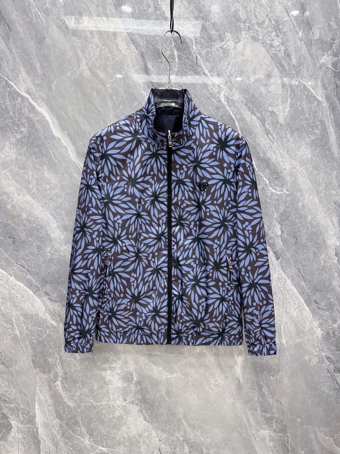 NO:956570,Prada 2026 autumn and winter new style | Prada double-sided stand-up collar jacket. Wear it twice, switch between two styles at will. The front is simple and solid navy blue, the triangular metal logo is low-key and elegant, versatile for commuting and business. The back is fully printed with blue floral jacquard, full of artistic atmosphere, and will not conflict when going out. Thin windproof and wrinkle-resistant fabric, light and weight-free, suitable for early autumn alone or late winter inner layering  Elastic cuffs at the hem, the shape is flattering and not flattering. Sizes M-3XL, prada, prada, jackets & coats,19860909普拉达 2026秋冬新款｜Prada双面立领夹克 一衣两穿,两种风格随心切换 正面简约藏青纯色,三角金属徽标低调显贵,通勤商务百搭 反面满印蓝调花卉提花,艺术氛围感拉满,出门不撞款 轻薄防风抗皱面料,轻便无负重,初秋单穿、深冬内搭都合适 松紧收口袖口下摆,版型修饰身形,不挑身材 尺码M-3XL,,prada,prada,jackets & coats,,Men's clothing