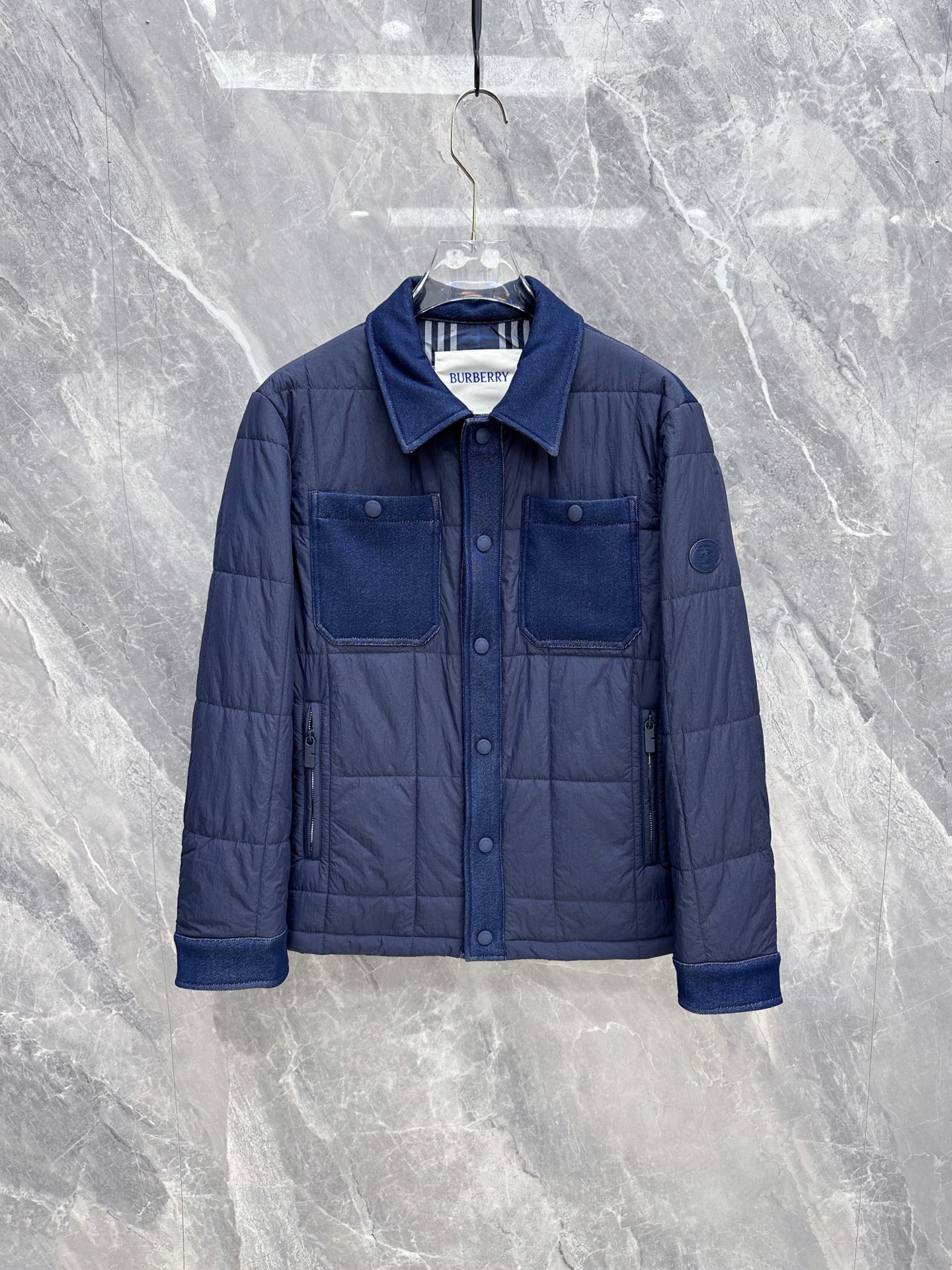 NO:956589,Burberry 2026 new autumn and winter | Navy blue spliced plaid thin cotton work shirt jacket. Denim contrast splicing design, uniform denim hemming on the collar, pockets, placket, and cuffs, full of layered texture. Checkered quilted fabric, light and thin to lock in warmth without being bulky, suitable for both early autumn alone and late autumn. Classic lapel shirt style, snap button closure, double side zipper pockets, both beautiful and practical  The round embossed brand logo on the cuffs, the classic plaid lining on the inside, and every detail highlights the light and luxurious tone. The low-saturated navy color is calm and elegant, suitable for business commuting, daily leisure, and short-distance travel. It is a universal style for middle-aged and young men. Sizes M-3XL,,burberry,burberry,jackets & coats,shirts,19860909Burberry 巴宝莉 2026秋冬新款｜藏蓝拼接格纹薄棉工装衬衫夹克 牛仔撞料拼接设计,领部、口袋、门襟、袖口统一牛仔包边,层次质感拉满 方格衍缝夹棉面料,轻薄锁温不臃肿,初秋单穿、深秋内搭双重适配 经典翻领衬衫版型,按扣开合,双侧拉链插袋兼顾美观与实用性 袖口圆形品牌浮雕标识,内里经典格纹内衬,细节处处彰显轻奢调性 低饱和藏蓝配色沉稳大气,商务通勤、日常休闲、短途出行都能驾驭,中年青年男士通用款 尺码M-3XL,,burberry,burberry,jackets & coats,shirts,,Men's clothing