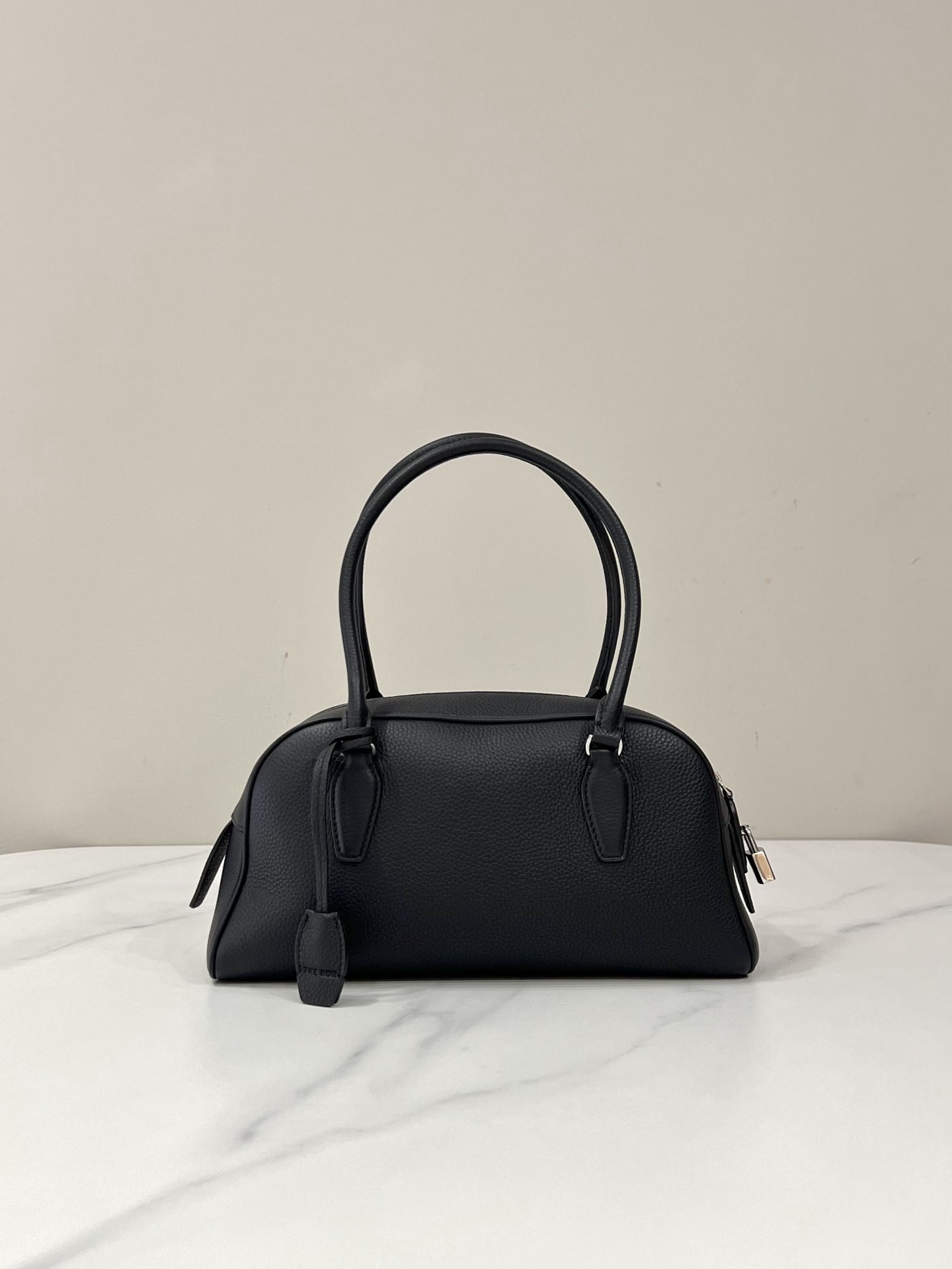 Sac bowling The Row en cuir de veau grainé, doublure en agneau, anses longues