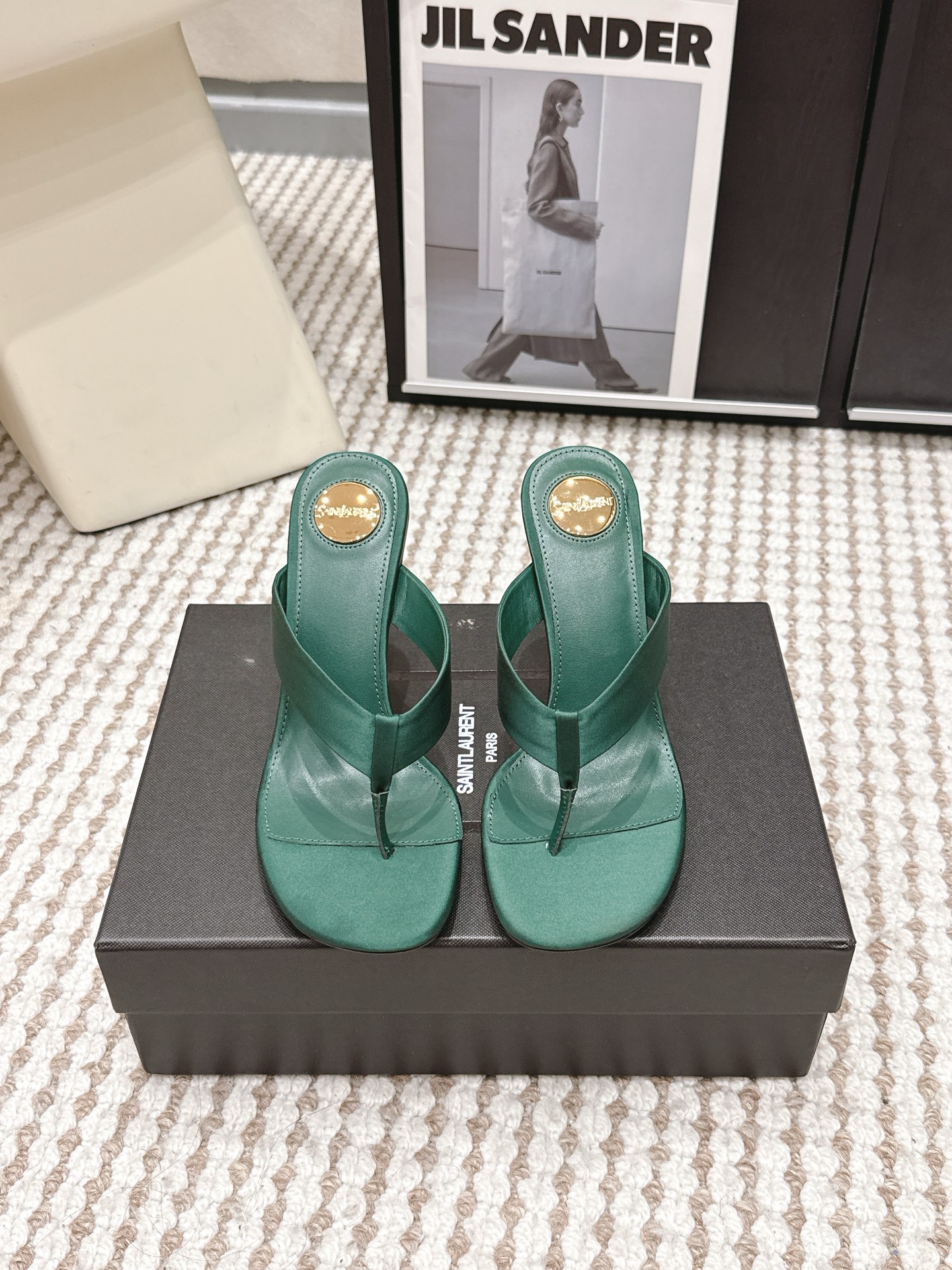 NO:783879,Purchasing agent Saint Lauren*·26s spring and summer new round toe gold logo and flip-flops  The structure of the herringbone toe is the most honest of all shoe styles - the instep, toe seams and arches are barely exposed, like a statement without annotation. The outline of the round toe pulls this frankness in a soft direction, no longer sharp, but still firm. The lines of the entire pair of shoes intersect into a simple 'human' character on the instep, like the first main beam in a freehand painting, supporting all the white space behind. Heel gold logo  The logo is not a printed signature, but an embedded signature. Every time you lift your foot, a trace of matte gold briefly flashes, like the gloss of coated paper worn out by the edge of an old book cover after being read countless times - not dazzling, but impossible to ignore. The person wearing these shoes is probably the kind of jeans that does not require any effort. The feet are rolled up twice, or a long skirt is dragging on the floor. The gold on the heel occasionally shows up in the undulations of the fabric, like a last name that does not need to be said. Material Silk  Sheep lining, outsole imported from Italy, genuine leather outsole, heel height 8.5cm, shoe size 35-39/40, 41 customization, non-returnable, split-toe shoes, saint laurent, skirts, jeans, real silk, Leather soles19860909代购级 Saint Lauren*·26s 春夏新款 圆头金色logo跟人字夹趾拖 人字夹趾的结构,是所有鞋款里最诚实的一种——几乎不加掩饰地袒露着脚背、趾缝与足弓,像一段不加注释的陈述句.圆头的轮廓将这种坦率往柔和的方向拉了一把,不再锋利,却依然笃定.整双鞋的线条在脚背交汇成一个简洁的“人”字,如同一笔写意画里最先落下的那根主梁,撑起了后面所有的留白. 鞋跟金色 logo 标识,不是印上去的签名,而是嵌进去的落款.在每一次抬脚时短暂地闪过一道哑金色的痕迹,像旧书封面边缘被翻阅过无数次之后磨出的铜版纸光泽——不刺眼,却无法被忽略.穿这双鞋的人,大约是不需要用力的那种牛仔裤脚随意卷两圈,或者一条长半裙曳地而行,鞋跟上的金色就在布料起伏间偶尔露一面,像一个不必说出口的姓氏. 材质真丝 内里羊里 大底意大利进口真皮大底 跟高8.5cm 鞋码35-39/40 41定制不退换,分趾鞋,saint laurent,skirts,jeans,real silk,Leather soles,Women's Shoes