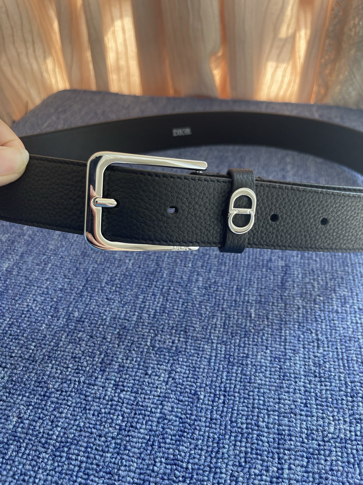 采用黑色粒面牛皮革精心制作，饰以镌刻有 Dior 的针扣和黑色金属覆层铜合金 CD Icon 标志腰带环