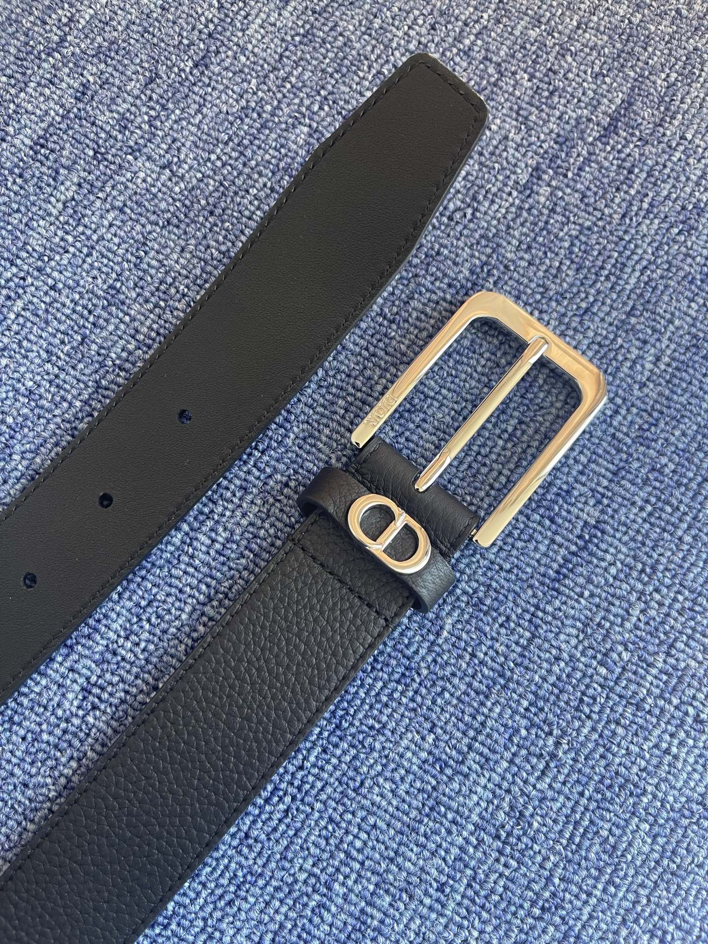 采用黑色粒面牛皮革精心制作，饰以镌刻有 Dior 的针扣和黑色金属覆层铜合金 CD Icon 标志腰带环