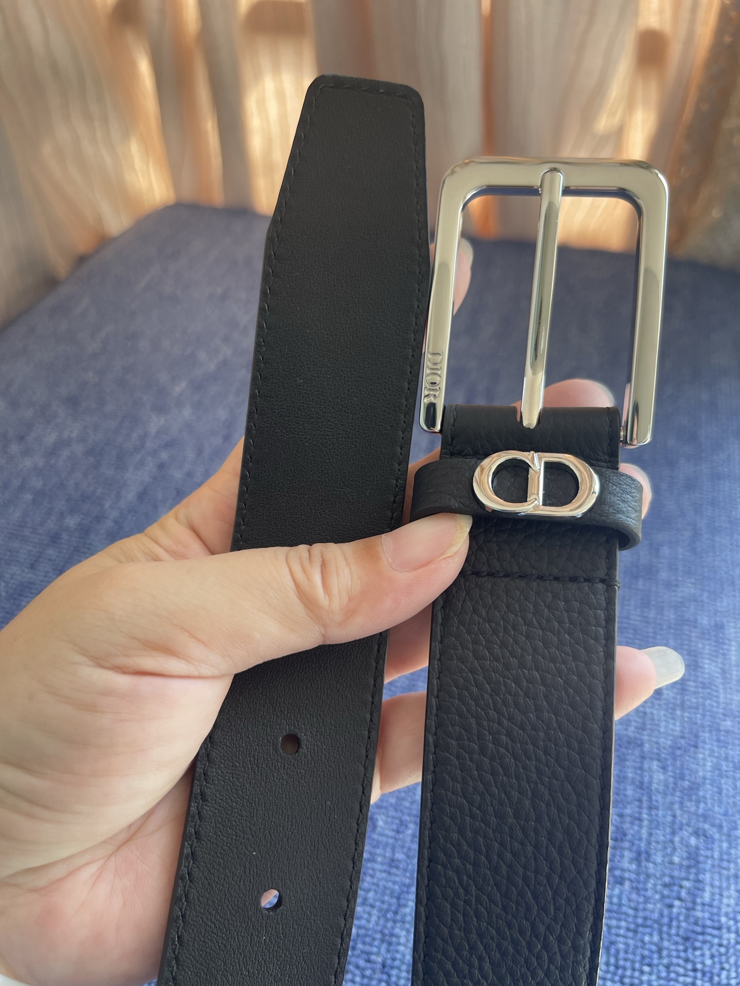 采用黑色粒面牛皮革精心制作，饰以镌刻有 Dior 的针扣和黑色金属覆层铜合金 CD Icon 标志腰带环