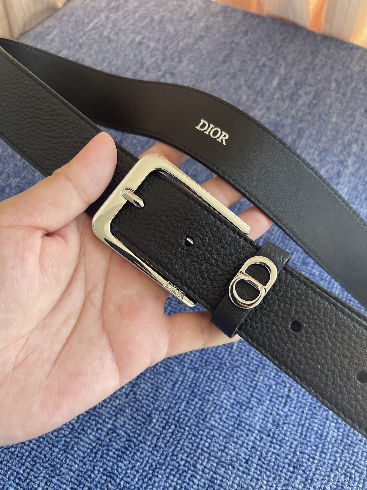 采用黑色粒面牛皮革精心制作，饰以镌刻有 Dior 的针扣和黑色金属覆层铜合金 CD Icon 标志腰带环