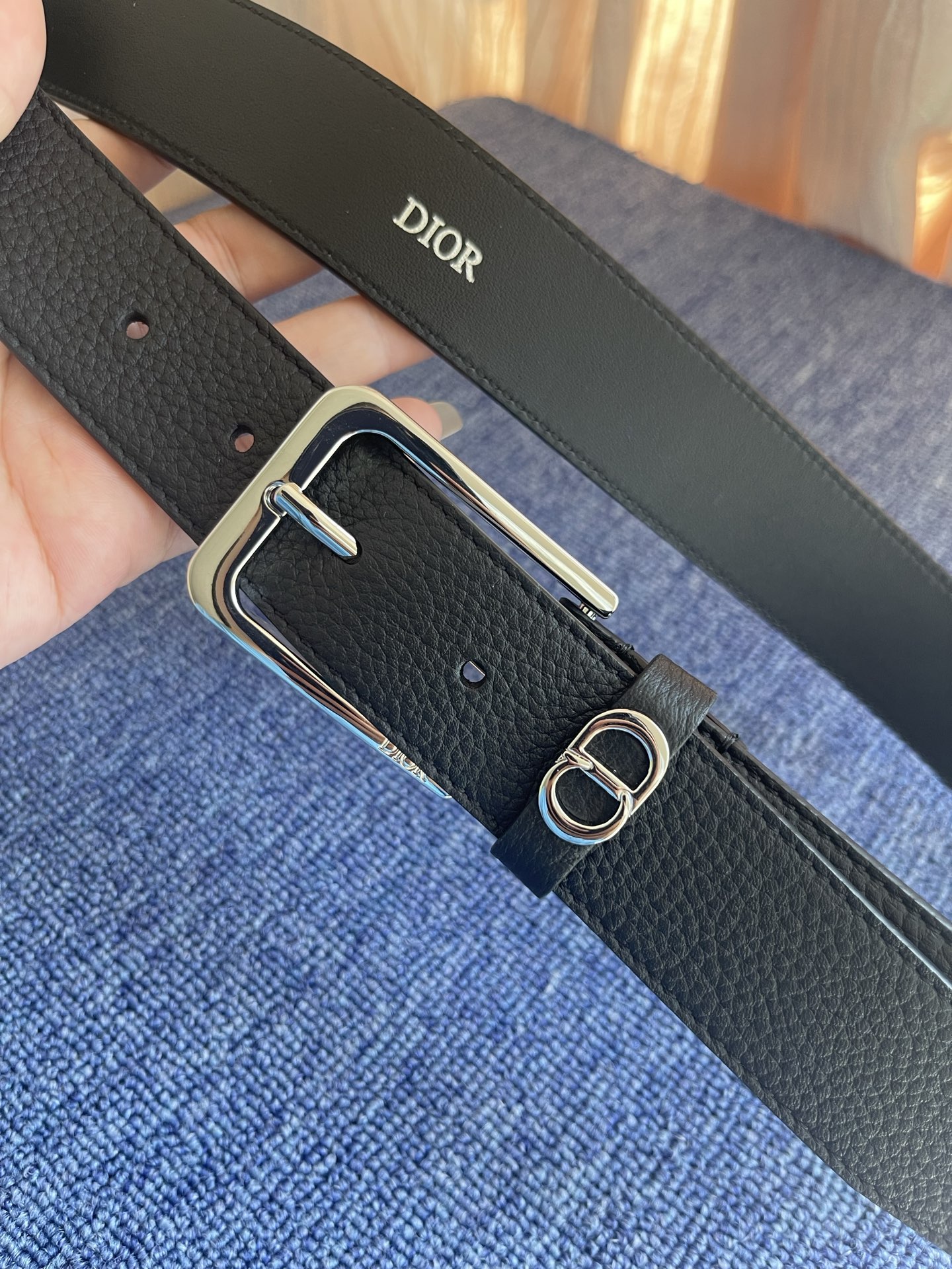 采用黑色粒面牛皮革精心制作，饰以镌刻有 Dior 的针扣和黑色金属覆层铜合金 CD Icon 标志腰带环