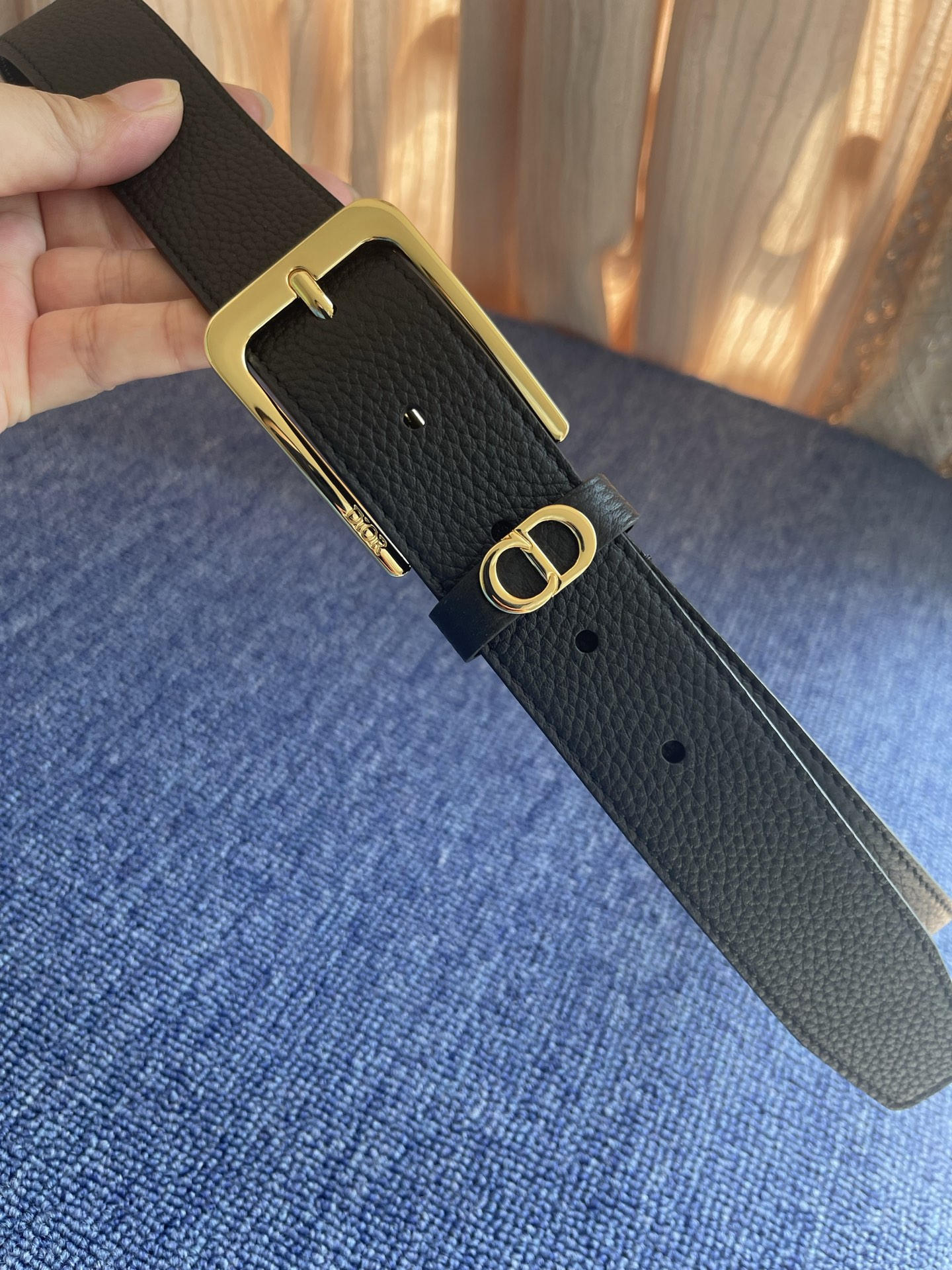 采用黑色粒面牛皮革精心制作，饰以镌刻有 Dior 的针扣和黑色金属覆层铜合金 CD Icon 标志腰带环