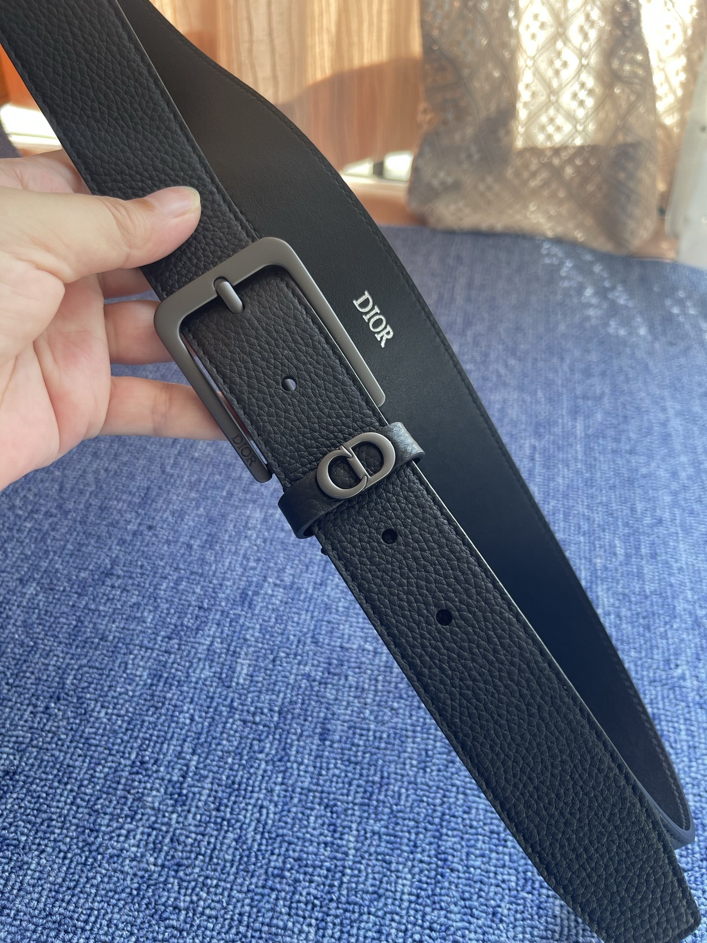 采用黑色粒面牛皮革精心制作，饰以镌刻有 Dior 的针扣和黑色金属覆层铜合金 CD Icon 标志腰带环