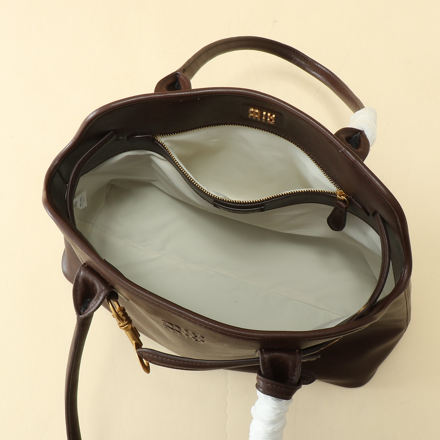 🐂 MiuMiu官网女包
这款AventureNap-pa皮革手袋灵感源自MiuMi u典藏设计，结构经