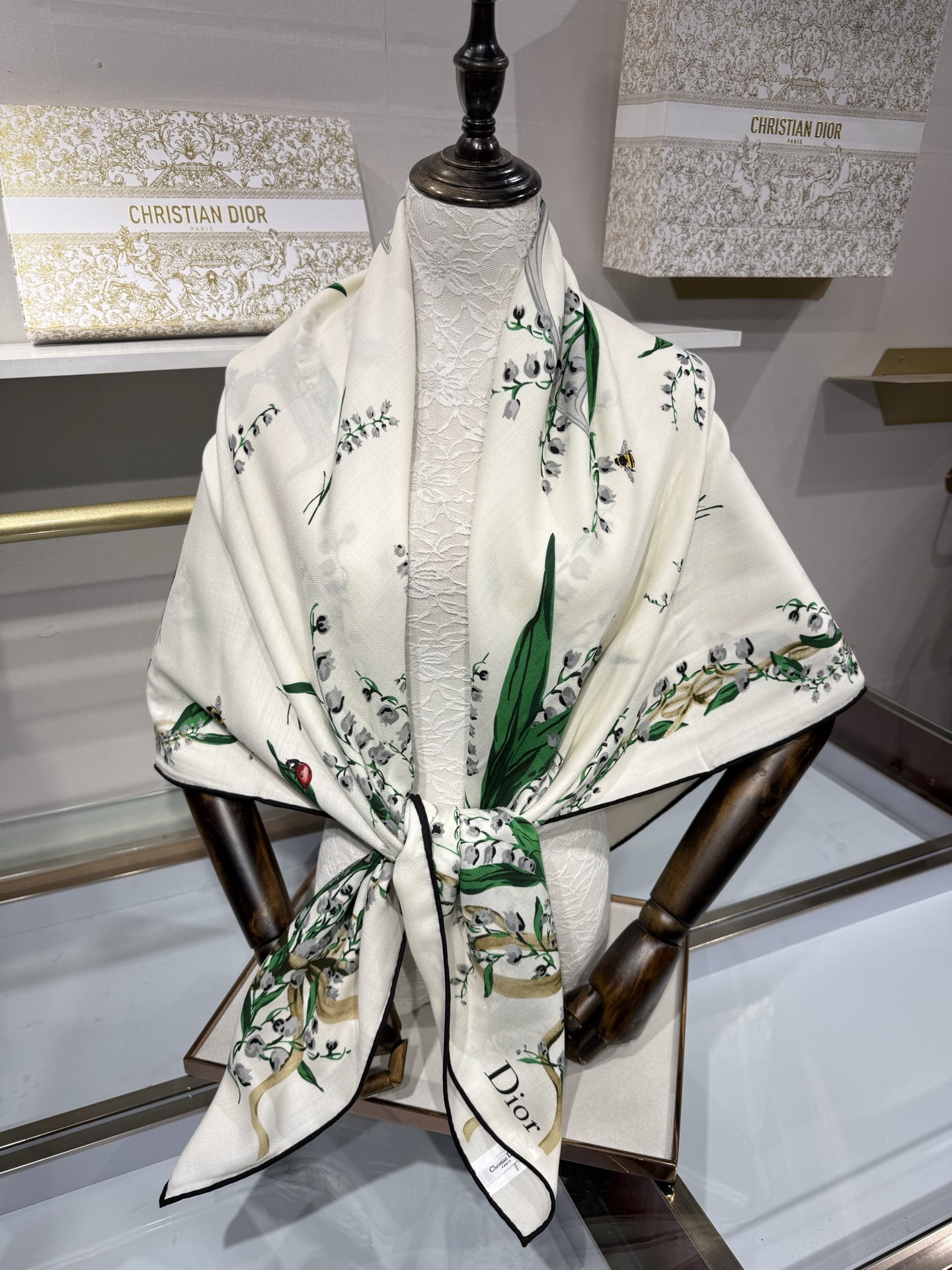 26年秋冬新品这款140丝绒披肩采用了Dior标志性的铃兰（Lily of the Valley）印花，白底绿叶搭配金色