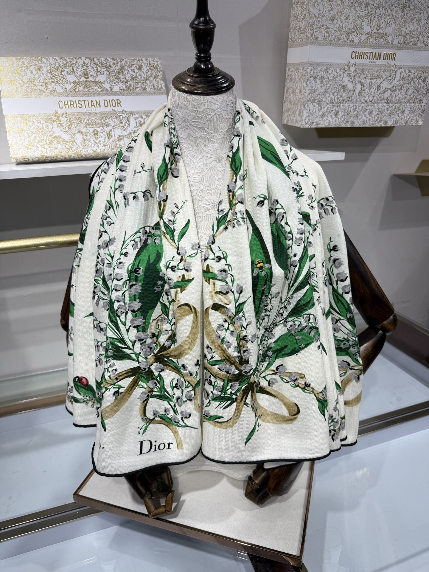 26年秋冬新品这款140丝绒披肩采用了Dior标志性的铃兰（Lily of the Valley）印花，白底绿叶搭配金色