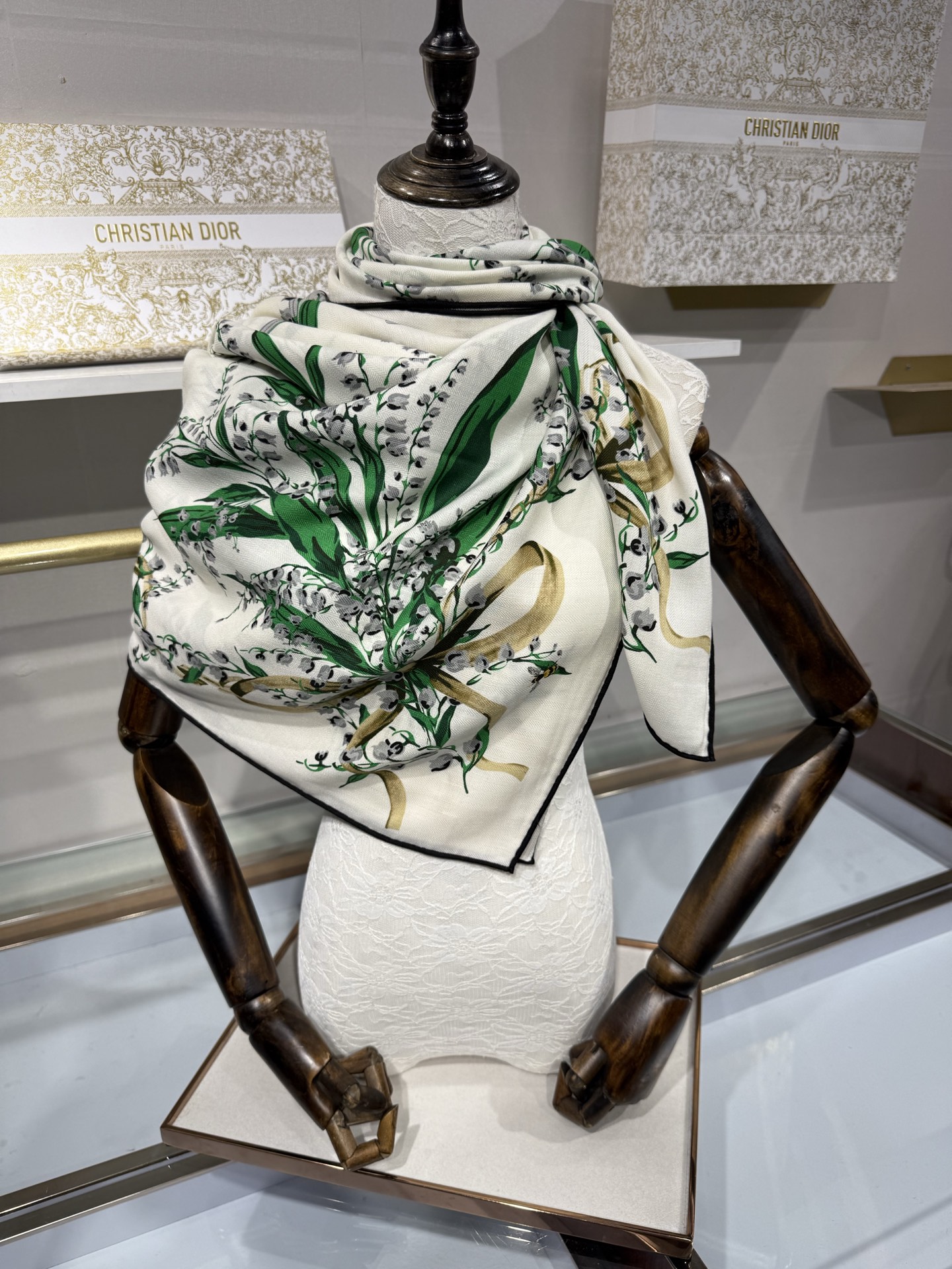 26年秋冬新品这款140丝绒披肩采用了Dior标志性的铃兰（Lily of the Valley）印花，白底绿叶搭配金色