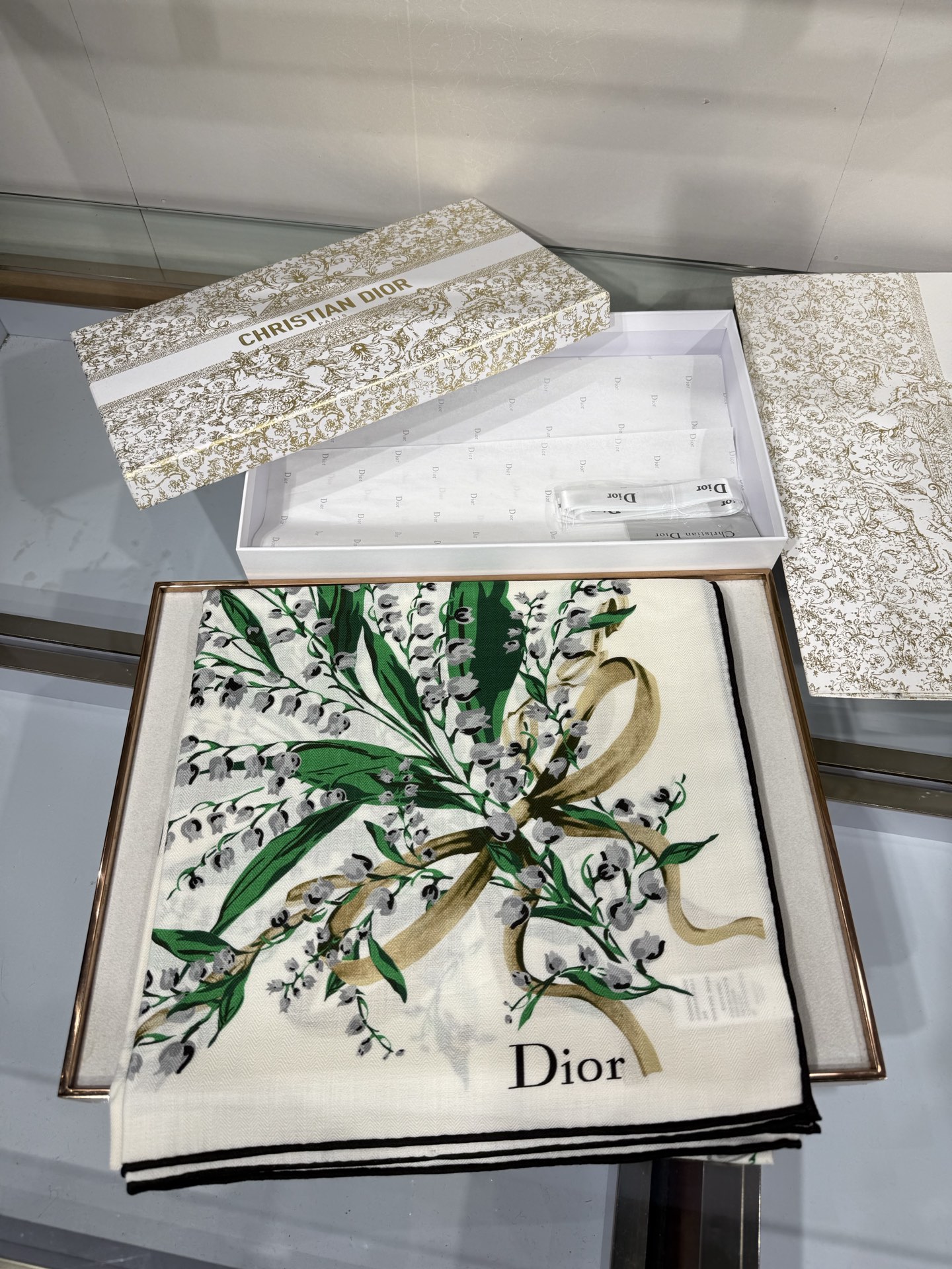 26年秋冬新品这款140丝绒披肩采用了Dior标志性的铃兰（Lily of the Valley）印花，白底绿叶搭配金色
