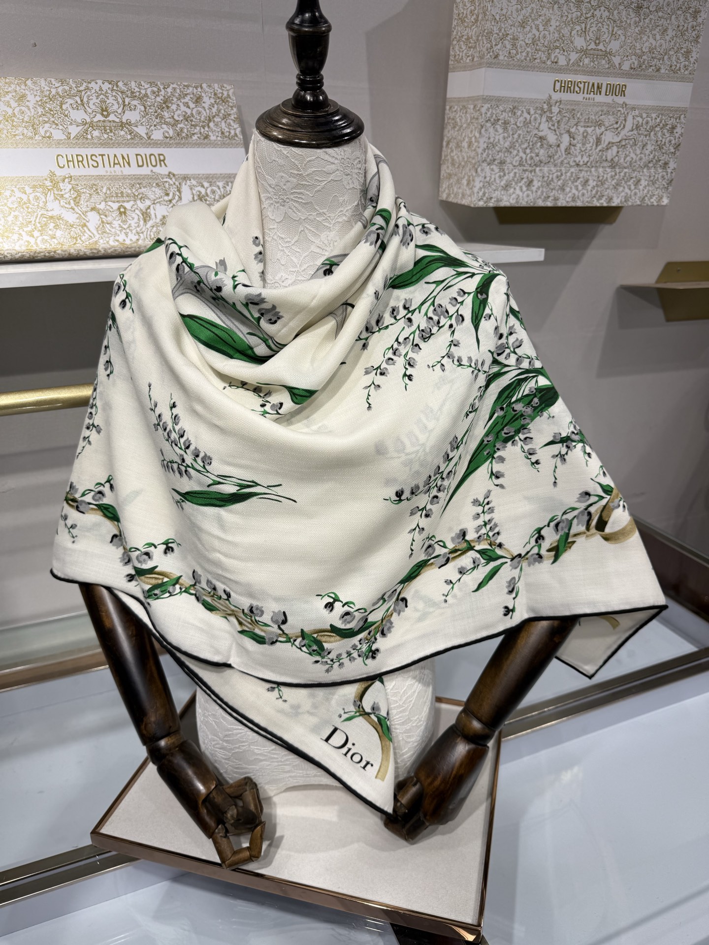 26年秋冬新品这款140丝绒披肩采用了Dior标志性的铃兰（Lily of the Valley）印花，白底绿叶搭配金色
