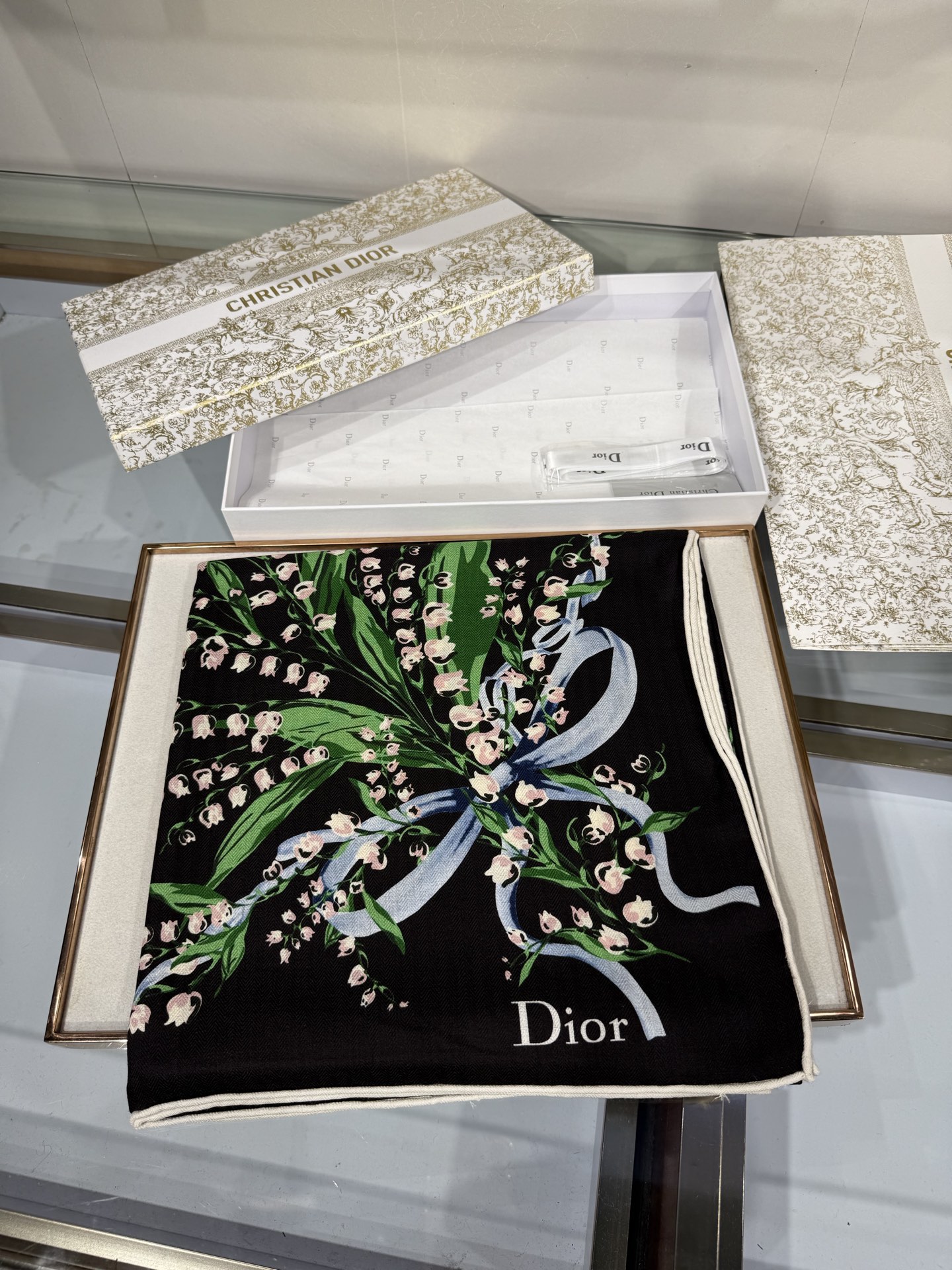 26年秋冬新品这款140丝绒披肩采用了Dior标志性的铃兰（Lily of the Valley）印花，白底绿叶搭配金色