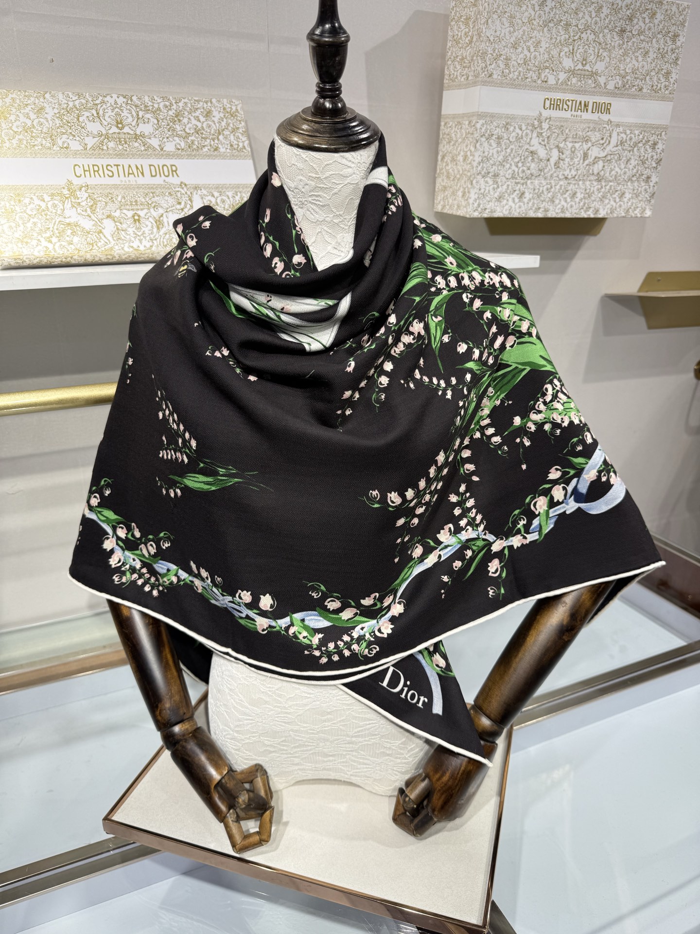 26年秋冬新品这款140丝绒披肩采用了Dior标志性的铃兰（Lily of the Valley）印花，白底绿叶搭配金色