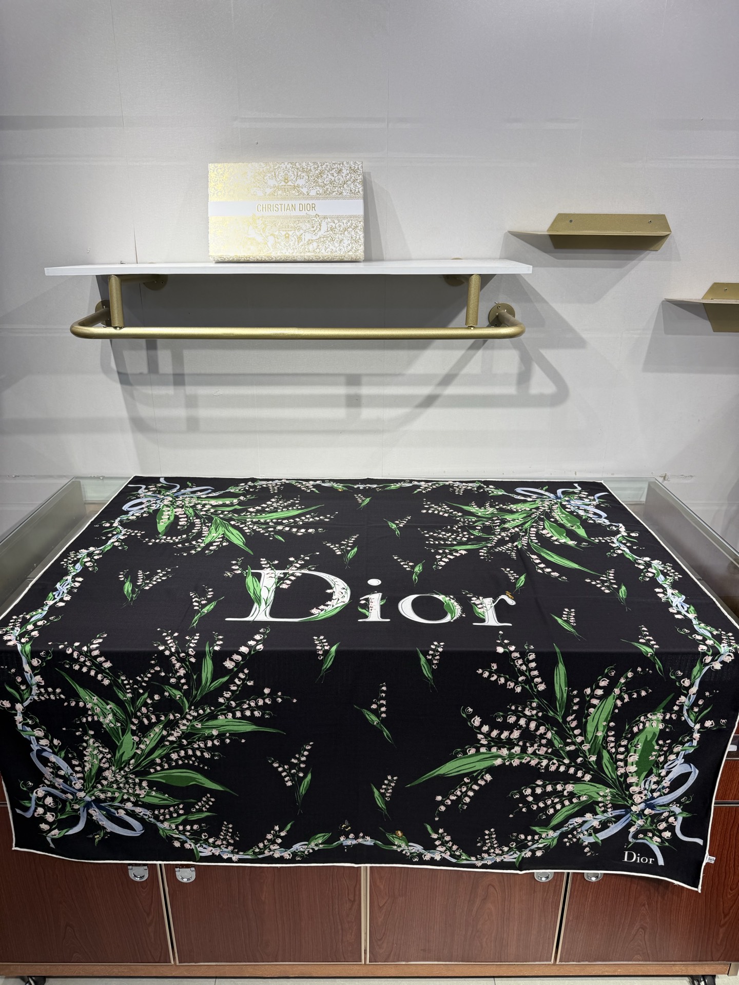 26年秋冬新品这款140丝绒披肩采用了Dior标志性的铃兰（Lily of the Valley）印花，白底绿叶搭配金色