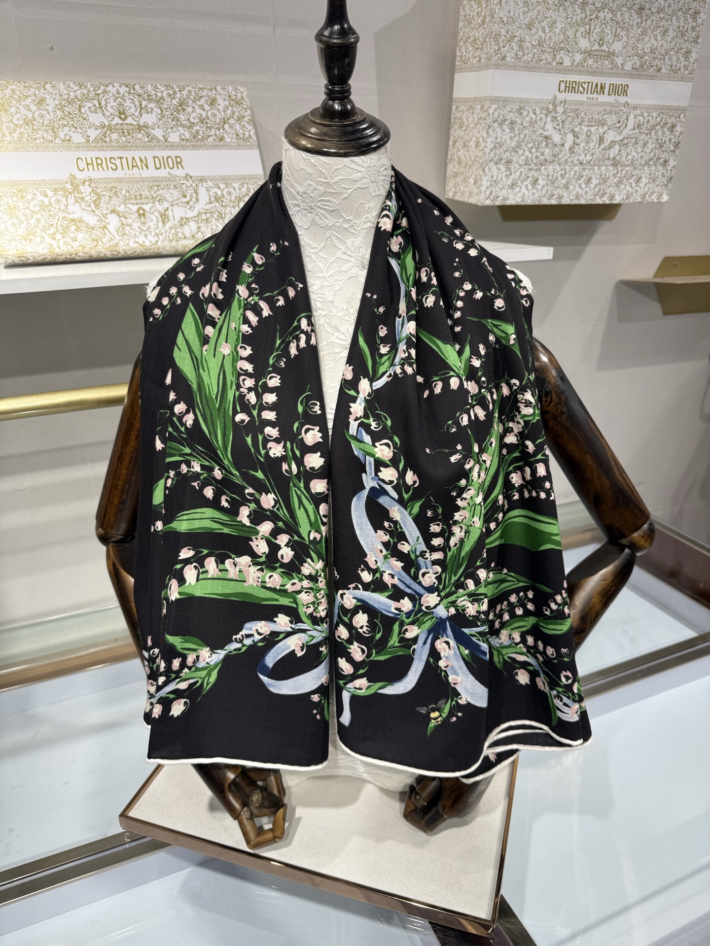 26年秋冬新品这款140丝绒披肩采用了Dior标志性的铃兰（Lily of the Valley）印花，白底绿叶搭配金色