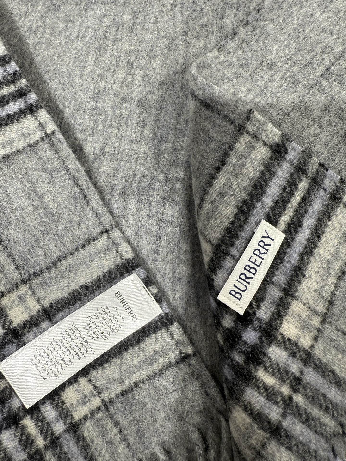 💟BURBERRY 博柏利 双面马术骑士（战马）羊恙绒围巾 双面两用羊恙绒围巾，一面纯色灰咖，一面复古格纹，正面刺绣马术