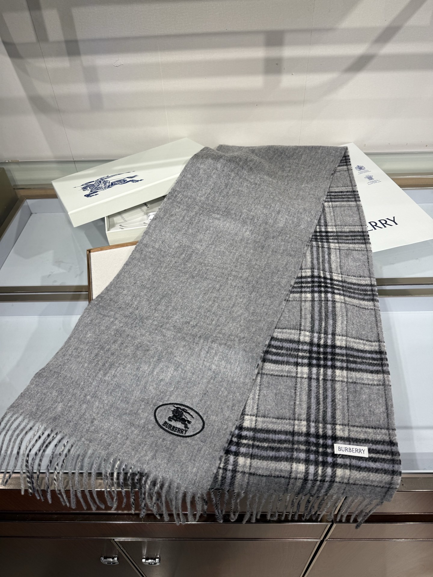 💟BURBERRY 博柏利 双面马术骑士（战马）羊恙绒围巾 双面两用羊恙绒围巾，一面纯色灰咖，一面复古格纹，正面刺绣马术