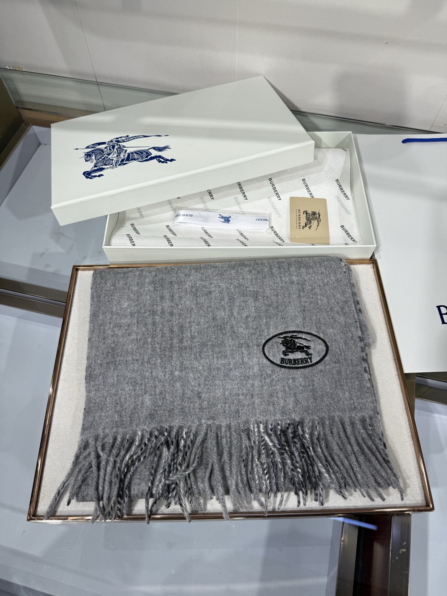 💟BURBERRY 博柏利 双面马术骑士（战马）羊恙绒围巾 双面两用羊恙绒围巾，一面纯色灰咖，一面复古格纹，正面刺绣马术