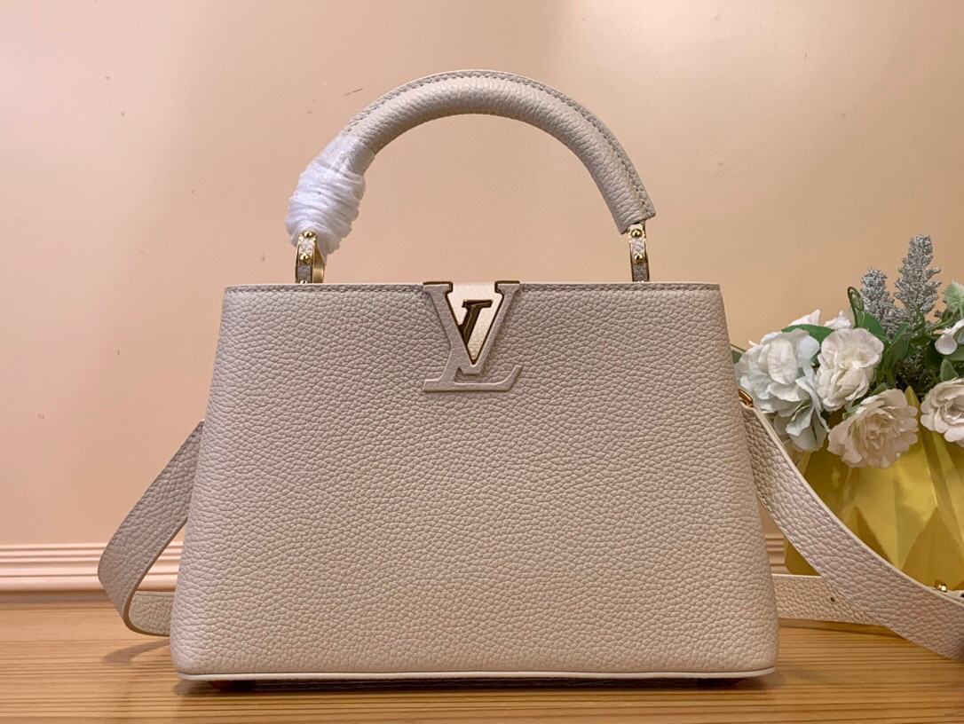 NO:619819,New shoulder strap Top original single [Caucines BB handbag] m24656 light blue m24655 flint gray m25087 off-white m24736 elephant gray m24728 black The now classic Caucines BB Sn handbag is made of full-grain Taurillon leather, displaying many of House’s signature leather-wrapped LV initials, a jewel-like handle bracket inspired by the historical tree trunk, and a Monogram  Unique flap in Flower pattern. Timeless and elegant, this charming model can be carried by the hand or worn cross-body on the removable strap. First launched in 2013, Caucines is named after the Paris street where Louis Vuitton first opened its store in 1854. Dimensions 27 x 17.3 x 9 cm 108121150,,louis vuitton,louis vuitton19860909新款肩带 顶级原单【Caucines BB 手袋】m24656 浅蓝色 m24655 燧石灰 m25087 米白色 m24736 象灰色 m24728 黑色 现在经典的Caucines BB Sn手提包由全粒面Taurillon皮革制成,展示了许多House的签名皮革包裹的LV首字母,灵感来自历史树干的珠宝般的手柄支架,以及带有Monogram Flower图案的独特翻盖.永恒优雅,这个迷人的模型可以手拿,也可以在可拆卸的带子上佩戴斜挎.Caucines于2013年首次推出,以路易威登于1854年首次开店的巴黎街道命名. 尺寸27 x 17.3 x 9 厘米 108121150,,louis vuitton,louis vuitton,Bag