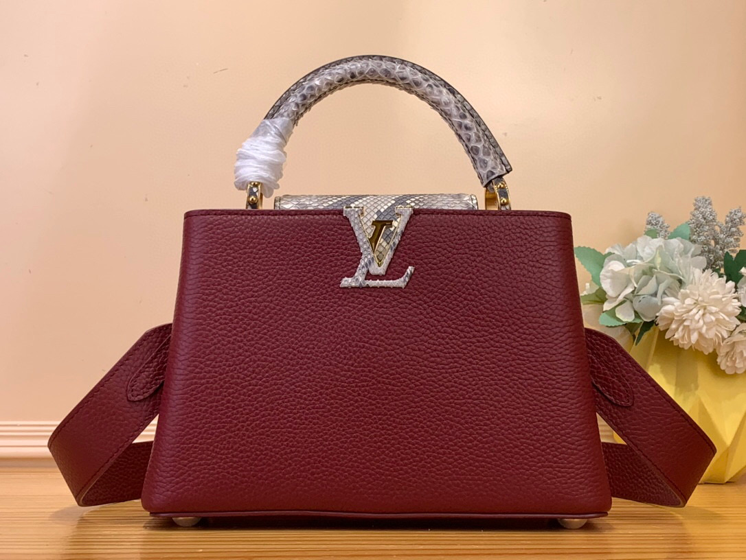 NO:551046,Top Original [Caucines bb Handbag] m22876 Burgundy (Snake Lid) The Caucines bb sn handbag features light blue Taurillon leather with a refined feminine appeal juxtaposed with precious Karung leather on the flap and top handle. Although soft to the touch, the Karung leather is extremely durable, making it durable. In addition to the iconic top handle, the Caucines also features a wide removable shoulder strap. Size 27-18-9  cm.116121250,19860909顶级原单【Caucines bb手袋】m22876 酒红色（蛇盖） Caucines bb sn手袋采用浅蓝色Taurillon皮革,具有精致的女性魅力,在翻盖和顶部手柄上与珍贵的Karung皮革并列.虽然触感柔软,但Karung皮革非常耐用,使其经久耐用.除了标志性的顶部手柄外,Caucines还配有宽大的可拆卸肩带. 尺寸27-18-9 厘米.116121250,,Bag