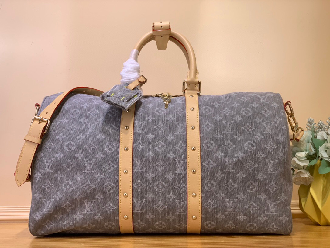 NO:551107,Top original order [KEEALL BANDOULIRE 45 Travel Bag] m13748 Gray/Denim This Keeall Bandoulière 45 Hx travel bag is made of Monogram Denim fabric, which is set against the cow leather trim and glossy metal parts, showing an elegant style in a low-key manner. The rivets on the side pay tribute to the brand's long trunk-making heritage, and the top handle and detachable and adjustable shoulder strap provide a variety of carrying options. Size 27 x 20 x  45 cm (height x width x length).8219095,,cowhide19860909顶级原单【KEEALL BANDOULIRE 45 旅行袋】 m13748 灰色/牛仔 本款 Keeall Bandoulière 45 Hx旅行袋取材 Monogram Denim织物,与牛皮革饰边和莹泽金属件相互映衬,于低调之中展露雅致格调.侧带铆钉致敬品牌悠久的制箱传承,顶部手柄和可拆卸并调节肩带提供多种背携选择. 尺寸27 x 20 x 45 厘米 (高 x 宽 x 长度).8219095,,cowhide,Bag