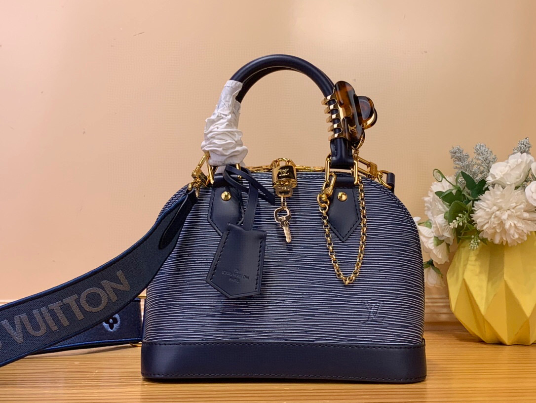 NO:551663,Top Original [Alma BB] m14853 Blue/Water Ripple (clip sold separately) The iconic Alma BB tote is reimagined in Ei St leather with a cool denim blue finish. The textured effect is complemented by gold hardware, including a signature padlock and keybell. The interior is lined with the house's signature Monogram denim and is sized for everyday essentials. Use the textile strap for hands-free operation. Dimensions 23.5 x 17.5 x  11.5 cm 7618085 (length x height x width),19860909顶级原单【Alma BB】 m14853 蓝色/ 水波纹（夹子需另外购买） 标志性的Alma BB手提包由Ei St皮革重新设计,具有酷炫的牛仔蓝色饰面.纹理效果与金色硬件相辅相成,包括标志性的挂锁和钥匙铃.内饰内衬有房子的标志性Monogram牛仔布,尺寸适合日常必需品.使用纺织表带进行免提操作. 尺寸23.5 x 17.5 x 11.5厘米 7618085（长x高x宽）,,Bag