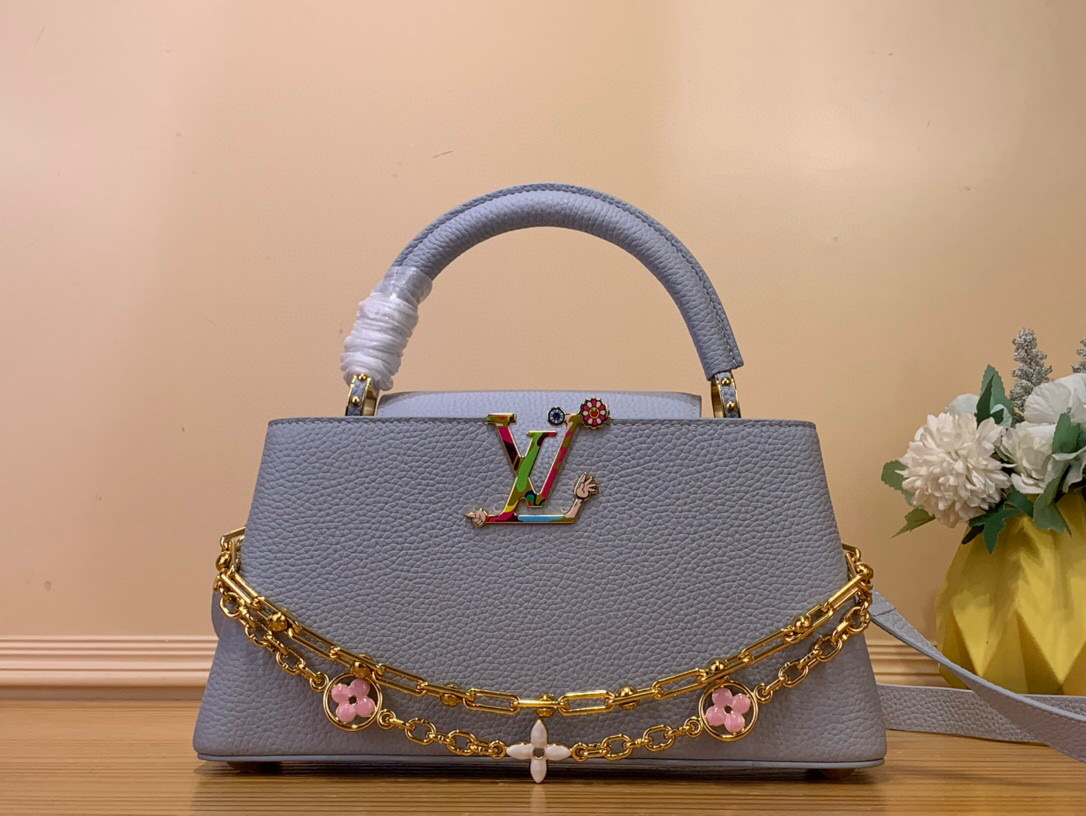 NO:551952,[LV x TM - Sac Caucines East West Mini] m13707 Blue/Takashi Murakami This Caucines East West mini bag is an extraordinary piece transformed by the playful code of the reissued Louis Vuitton  Borrowed from Murakami's original rainbow color palette. The iconic LV initials on the front and the Monogram flower on the upgraded chain are reinvented in an original way in the artist's own Suerflat style. Dimensions 28 cm 130121450 (LxHxW),,louis vuitton,louis vuitton,mini bags19860909【LV x TM - Sac Caucines East West Mini】 m13707 蓝色/ 村上隆 这款Caucines East West迷你包是Louis Vuitton x Murakami系列重新发行的俏皮代码所改变的非凡作品.他穿着柔和的蓝色Taurillon皮革,这种颜色是从Takashi Murakami的原始彩虹调色板中借来的.正面标志性的LV首字母和升级链条的Monogram花以艺术家自己的Suerflat风格以原创方式重新发明. 尺寸28 厘米 130121450（长x高x宽）,,louis vuitton,louis vuitton,mini bags,Bag