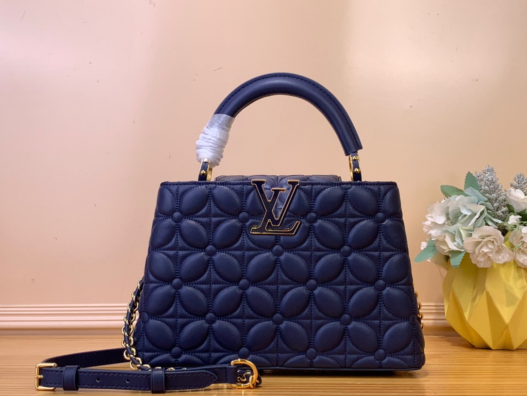 NO:552261,Top Original [Caucines bb Handbag] m25283 Dark Blue (Floral Pattern) Caucines bb Hl reimagines the quilted bloom effect for this season, paying homage to the iconic Monogram Flowers pattern. It is made of lambskin leather and decorated with sparkling gold hardware, including LV initials and a removable braid strap. The versatile design can be carried with the flap inward or outward. Dimensions 17.3 x 9 x 27 cm  130121450 (height x width x length),,louis vuitton,sheepskin19860909顶级原单【Caucines bb 手袋】 m25283 深蓝色（花卉图案） Caucines bb Hl为本季重新构想了绗缝绽放效果,向标志性的Monogram Flowers图案致敬.它由小羊皮皮革制成,饰有闪闪发光的金色五金,包括LV首字母缩写和可拆卸的编织带.多功能设计可以将襟翼向内或向外携带. 尺寸17.3 x 9 x 27 厘米 130121450 (高 x 宽 x 长度),,louis vuitton,sheepskin,Bag