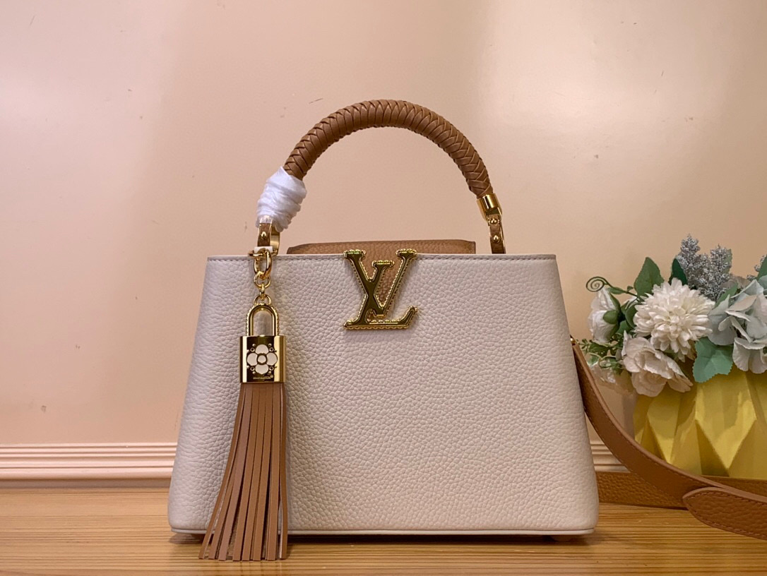 NO:552262,Top original list [CAUCINES BB Handbag] m25466 grey brown/tasseled (color combination) Crafty series once again gives Caucines BB Hl handbag the light of craftsmanship. Taurillon cowhide leather creates a classic configuration, and the woven handle adds a refined style. LV letters reflect the effect of flowering, and the detachable tassel hanging under the padlock. Dimensions 17.3 x 9 x 27 cm 140121500 (height x width x length),,louis vuitton,cowhide19860909顶级原单【CAUCINES BB 手袋】 m25466 灰色拼棕色/流苏（拼色） Crafty 系列再度赋予 Caucines BB Hl手袋匠心之光.Taurillon 牛皮革塑造经典构型,编织手柄再添考究格调.LV 字母映现拷花效果,挂锁下方悬挂可拆卸流苏. 尺寸17.3 x 9 x 27 厘米 140121500 (高 x 宽 x 长度),,louis vuitton,cowhide,Bag