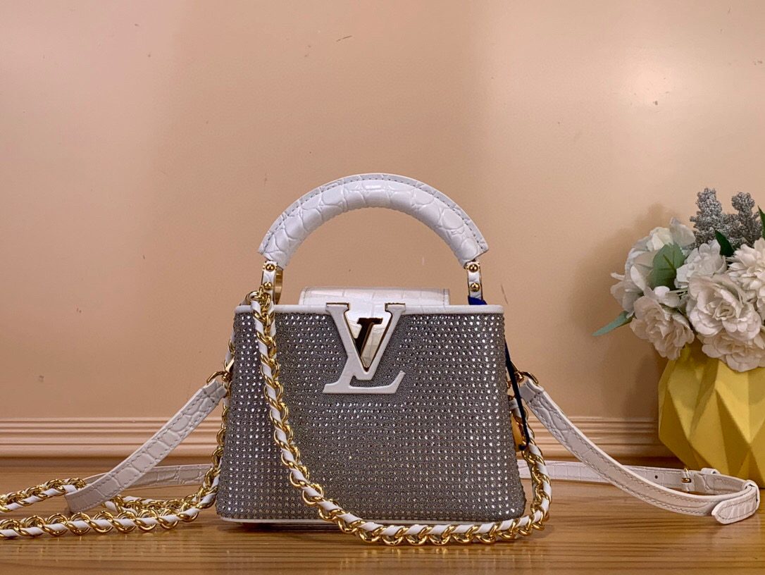 NO:552438,Top original order [capucines nano handbag] M83088 original imported crystal diamonds with original imported crocodile leather pattern, fully hand-set with diamonds, crystal diamonds and cowhide leather. This Capucines East-West mini handbag comes from the Exceptionals LV Sparkle series, lighting up the spring and summer show with complex design. Brilliant cut imitation crystal, all-steel chain ingeniously sewn into the cowhide base, LV  The letter logo pays tribute to the brand's long heritage. The flap can be placed externally or internally, and the detachable shoulder strap allows for a variety of styling possibilities. Can store a 6.7-inch smartphone, Capucines short wallet, lipstick and keys. The shoulder strap is detachable and adjustable. The half-length strap is 53.0 cm. The half-length strap is adjustable to 58.0 cm. Single handle. Size 12×   7×16cm.125121300,,louis vuitton,cowhide,crocodile skin19860909顶级原单【capucines nano手袋】M83088 原进口水晶钻 配原进口鳄鱼皮纹 全手工镶钻 水晶钻配牛皮本款 Capucines East-West 迷你手袋出自 Exceptionals LV Sparkle 系列,以繁复设计点亮 春夏秀场.璀璨的切割仿水晶,全钢链条匠心缝入牛皮革基底,LV 字母标识致意品牌悠久传承.翻盖可外置或内收,搭配可拆卸肩带实现多种造型可能. 可收纳 6.7 寸智能手机、Capucines 短款钱夹、口红和钥匙 肩带可拆卸,可调节 包带半长53.0 厘米 包带半长可调至58.0 厘米 手柄单手柄 尺寸12× 7× 16厘米.125121300,,louis vuitton,cowhide,crocodile skin,Bag