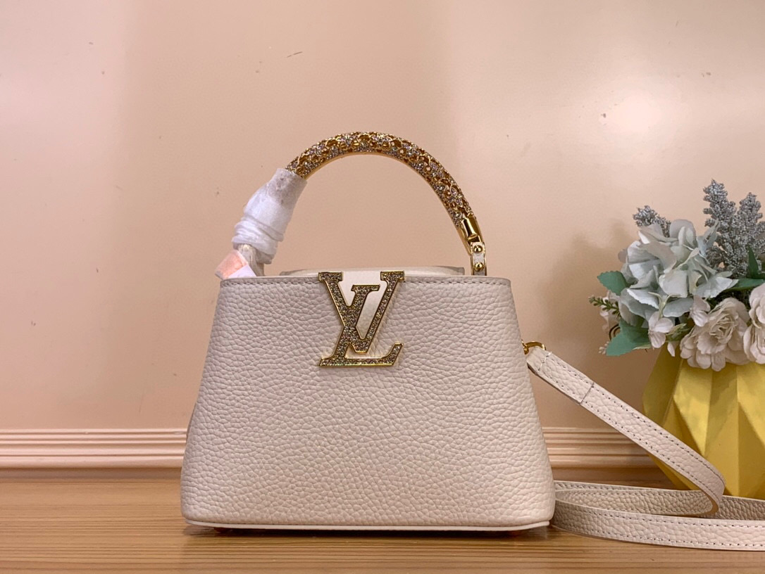 NO:581529,Top original order [CAUCINES mini handbag] m14177 White/Diamond handle This Caucines Hr mini handbag is from the Excetionals series, and is made of Taurillon leather. It is a good collection choice. Rhinestones inject jewelry texture into the LV letters, and the dazzling flower-shaped handle refers to the classic Flower Crown necklace design. You can switch to multiple carrying methods at will, and the clamshell can be folded in or out. Dimensions 13.6 x 8 x 21  cm.140121550 (height x width x length),,louis vuitton,necklace,cowhide19860909顶级原单【CAUCINES 迷你手袋】 m14177 白色/钻手柄 本款 Caucines Hr迷你手袋出自 Excetionals 系列,以 Taurillon 牛皮革演绎收藏佳选.莱茵石为 LV 字母注入珠宝质感,耀目花卉形状手柄援引经典 Flower Crown 项链设计.可随心切换多种背携方式,翻盖内收或外置皆宜. 尺寸13.6 x 8 x 21 厘米.140121550 (高 x 宽 x 长度),,louis vuitton,necklace,cowhide,Bag