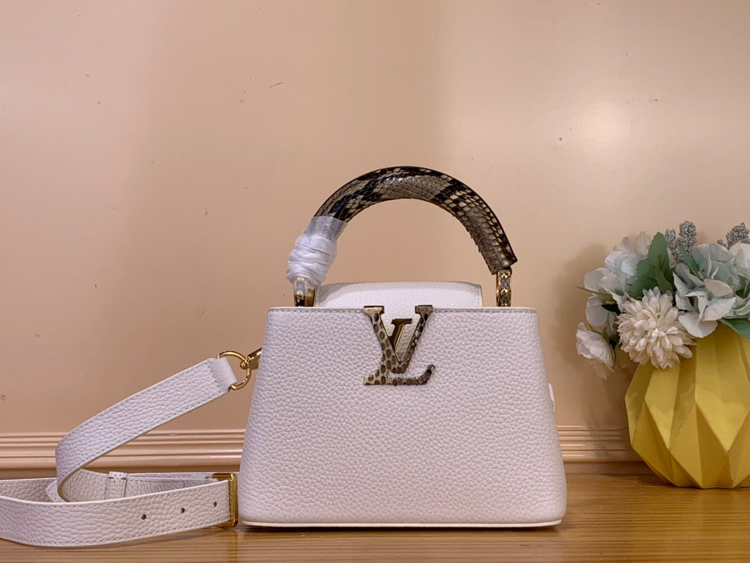 NO:581643,Top original order [CAUCINES mini handbag] N98477 48865 White (snake handle) Summer model Caucines mini handbag is made of Taurillon leather, and then the top handle and LV letters are wrapped in gorgeous python skin, adding a touch of exotic style to the iconic design. The detachable wide shoulder strap allows for a comfortable shoulder or cross-body experience. Dimensions 21.0 x 14.0 x 8.0 cm  108121150,,louis vuitton,snakeskin19860909顶级原单【CAUCINES 迷你手袋】 N98477 48865 白色（蛇柄） 夏季款 Caucines 迷你手袋取材 Taurillon 皮革,再以华美蟒蛇皮包裹顶部手柄及 LV 字母,令标志性设计融入一抹异域风情.可拆卸宽肩带实现舒适肩背或斜挎体验. 尺寸21.0 x 14.0 x 8.0 cm 108121150,,louis vuitton,snakeskin,Bag