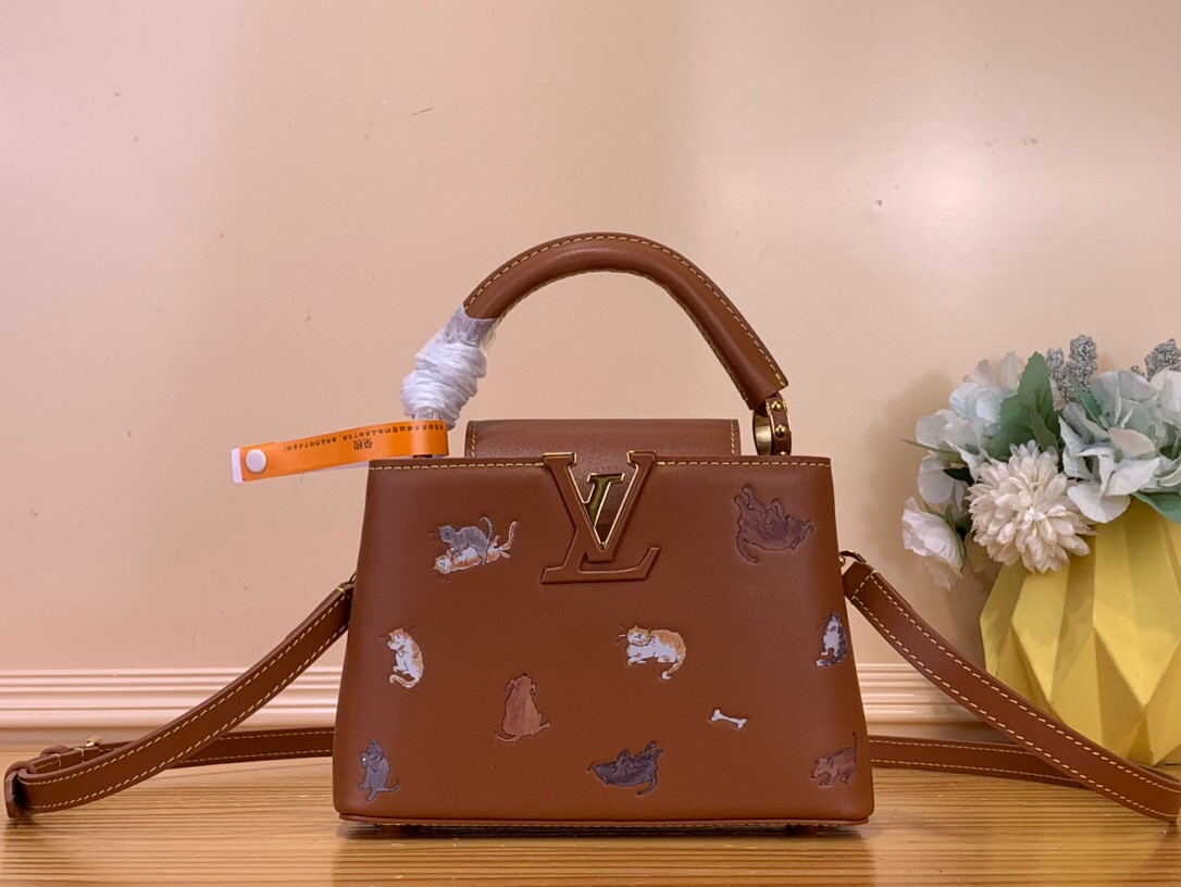NO:581647,Top original item [CAUCINES mini handbag] m25874 brown/cat LV Travels With series renders the Caucines mini hr handbag in classic colors, adding smart details with hand-drawn cat illustrations by fashion icon and artist Grace Coddington. This replica version originated from the first collaboration in 2019, with LV letters on the cowhide body. The flap can be folded in or out, and the detachable long shoulder strap allows for multiple carrying methods. Size 14 x  8 x 21 cm 112121250 (height x width x length),,louis vuitton,cowhide19860909顶级原单【CAUCINES mini 手袋】 m25874 棕色/猫咪 LV Travels With 系列为 Caucines mini hr手袋渲染经典色调,以时尚偶像兼艺术家 Grace Coddington 手绘的猫咪插画增添灵动细节.该复刻版本源自 2019 年的首次合作,为牛皮革包身搭配 LV 字母.翻盖适宜内收或外置,可拆卸长肩带实现多种背携方式. 尺寸14 x 8 x 21 厘米 112121250 (高 x 宽 x 长）,,louis vuitton,cowhide,Bag