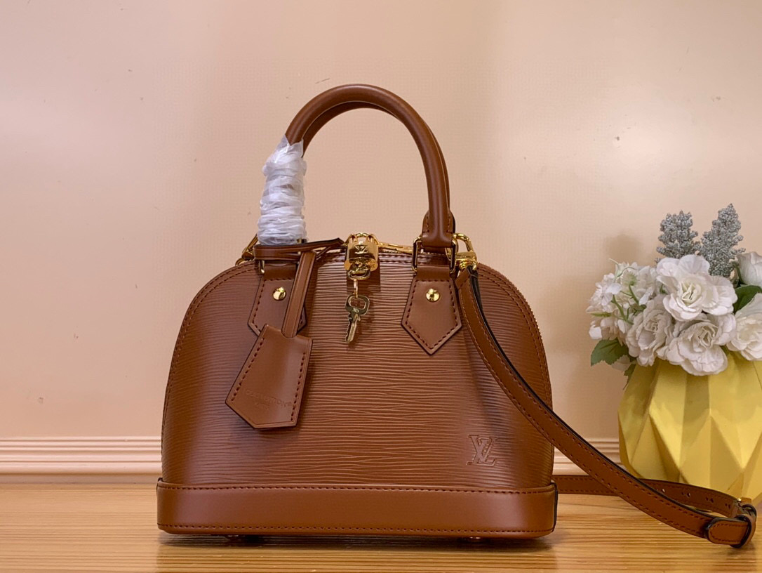 NO:602762,Top Original [Sac Alma BB] m25562 Brown / Water Wave The iconic Alma BB bag is revisited in this red Monogram Ei Bl leather version, inspired by Louis Vuitton lipstick. The gold metallic finish enhances the grain effect and includes a padlock and key bell. This model comes with an internal flat pocket for small personal items and can store daily essentials. The shoulder strap is removable and can be carried in the hand. Dimensions 23.5 x 17.5 x  11.5cm.6517075(lengthxheightxwidth),,louis vuitton19860909顶级原单【Sac Alma BB】 m25562 棕色 /水波纹 标志性的Alma BB包在这款红色Monogram Ei Bl皮革版本中重温,灵感来自路易威登口红.金色金属饰面增强了颗粒效果,包括挂锁和钥匙铃.该型号配有一个内部扁平口袋,可以存放小个人物品,可以存放日常必需品.肩带是可拆卸的,可以拿在手里. 尺寸23.5 x 17.5 x 11.5厘米.6517075（长度x高度x宽度）,,louis vuitton,Bag