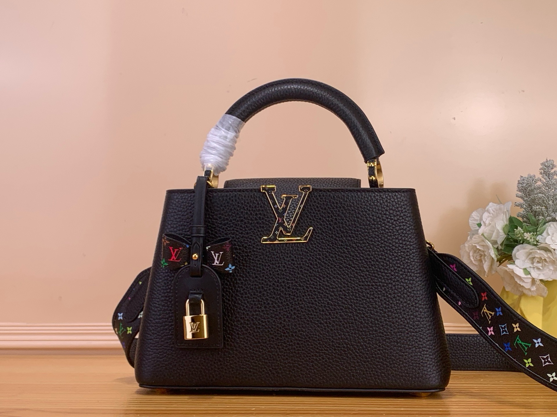 NO:676411,Top Original [LV x TM Caucines Handbags] m27636 Black / Murakami Caucines Bag Crafted with playful proportions, the Caucines bag makes a modern statement with the fresh green tones of Taurillon leather, inspired by the rainbow palette of Japanese artist Takashi Murakami HL. The LV initials, lining, key bell and strap all feature House  A cheerful, colorful version of the Monogram pattern serves as the accent, while gleaming gold hardware, including a removable chain, completes the look with a polished touch. Dimensions 21 x 14 x 8 cm 120121300,, louis vuitton19860909顶级原单【LV x TM Caucines 手袋】m27636 黑色/ 村上隆 Caucines 包以俏皮的比例制作,以Taurillon皮革的清新的绿色色调做出了现代声明,灵感来自日本艺术家Takashi Murakami hl的彩虹调色板.LV首字母、衬里、钥匙铃和表带都以House Monogram图案的欢乐多彩版本为重点,而闪闪发光的金色硬件,包括可拆卸的链条,以抛光的触感完成了外观. 尺寸21 x 14 x 8厘米 120121300,,louis vuitton,Bag