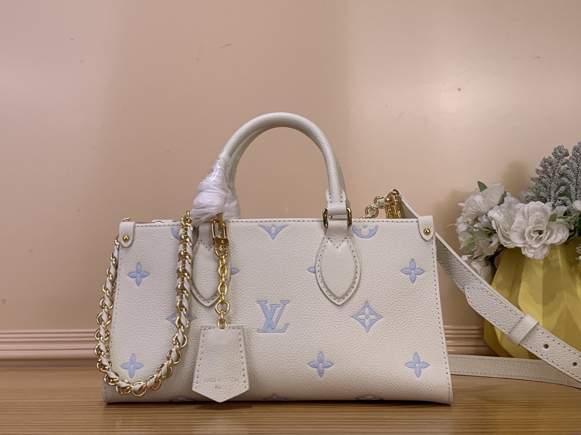 NO:701181,Top original order [ONTHEGO EAST WEST handbag] m27577 blue/silk screen (strawberry milk) This OnTheGo EW handbag is from the Monogram Emreinte Outline ys series, interpreting the new season fashion with elegant two-color. The Monogram Emreinte leather has an exquisite shape, the silver woven chain and unique charms are detachable, and the compartments are convenient for storing daily needs, and can be flexibly switched to a variety of carrying methods.  Dimensions 13 x 10 x 25 cm 8019095 (height x width x length),19860909顶级原单【ONTHEGO EAST WEST 手袋】 m27577 蓝色/丝印（草莓牛奶） 本款 OnTheGo EW 手袋出自 Monogram Emreinte Outline ys系列,以雅致双色演绎新季风尚.Monogram Emreinte 皮革塑造玲珑构型,莹泽编织链条和别致挂饰均可拆卸,隔层便于收纳日常所需,可灵活切换多种背携方式. 尺寸13 x 10 x 25 厘米 8019095 (高 x 宽 x 长度),,Bag