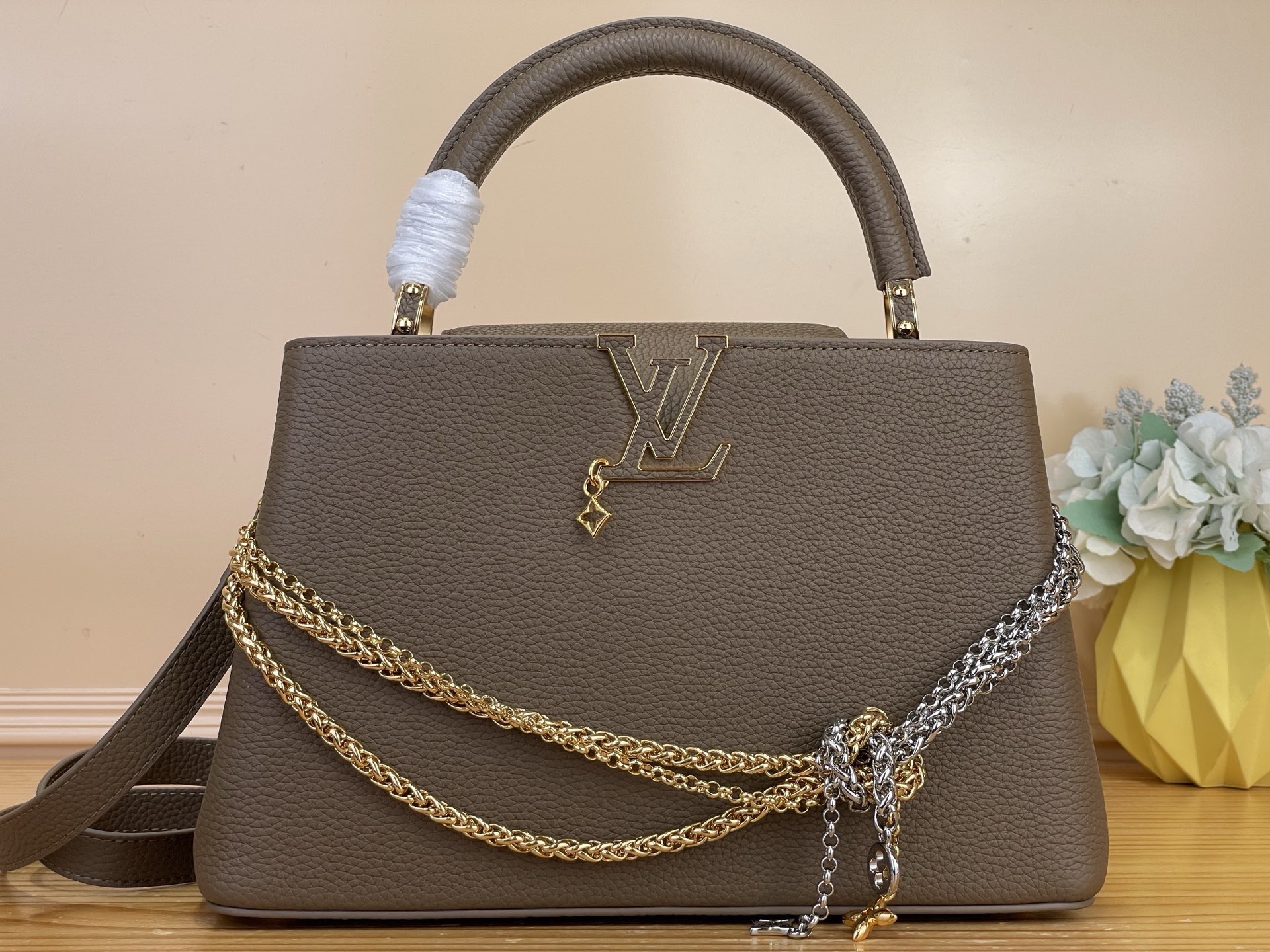 NO:812193,Top original order [CAUCINES medium handbag] m48865 taupe/tied chain. This Caucines medium handbag is made of fine Taurillon cow leather dip-dyed in deep tones, and paired with a double-plated chain that looks like jewelry, adding an elegant evening option to the Why Knot hl series. Monogram decoration and exquisite beading embellish the chain. The flap can be folded in or out to enrich carrying options. Size 31.05 x 20 x  11 cm 140121550 (length x height x width),,cowhide19860909顶级原单【CAUCINES 中号手袋】 m48865 灰褐色/绑结链条 本款 Caucines 中号手袋为细腻 Taurillon 牛皮革浸染深邃色调,并搭配宛若珠宝的双镀链条,为 Why Knot hl系列增添优雅晚宴佳选.Monogram 装饰与精美珠饰装点链条.可内收或外置的翻盖丰富背携选择. 尺寸31.05 x 20 x 11厘米 140121550（长x高x宽）,,cowhide,Bag