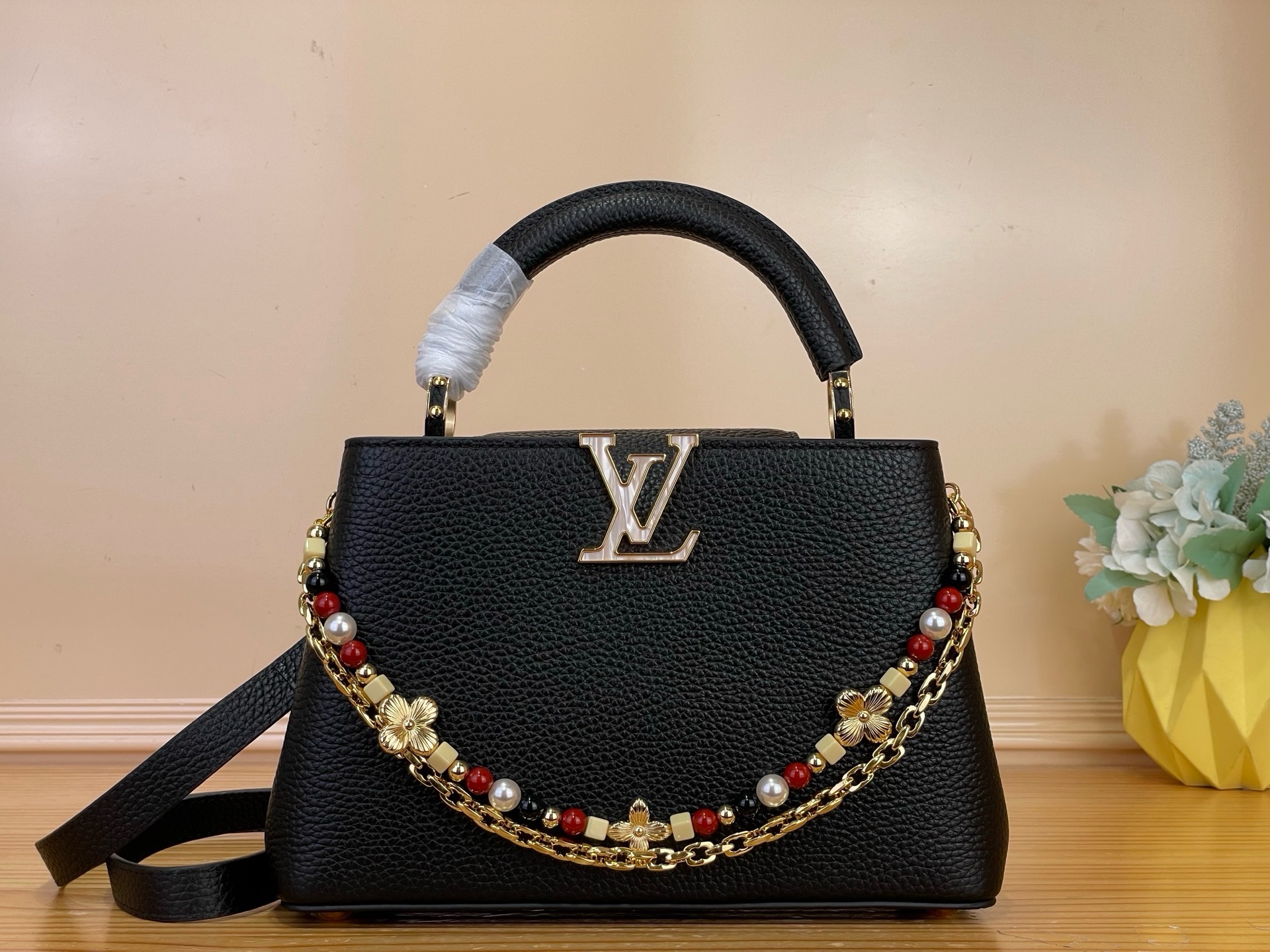 NO:879773,Top original item [CAUCINES BB handbag] M28455 black/floral double chain This Sunbeam series Caucines BB handbag is exquisite and elegant. It is made of grained Taurillon leather and decorated with decorative chains. One chain is equipped with hand-assembled links, just like fine jewelry; the other is decorated with glass beads and metallic Monogram Hl flowers, shining with charming luster. Embellished with the iconic LV  Letters, various carrying methods, inner compartments can store valuables in an orderly manner. This collection of exquisite pieces comes with exclusive packaging, imbued with the charming style of the Côte d'Azur. It comes with limited charms and the brand's iconic beach hut handbag to enjoy the leisurely mood of summer - limited edition, subject to availability. Dimensions 27 x 19 x 9 cm 128121350 (length x height x width),, louis vuitton19860909顶级原单【CAUCINES BB 手袋】 M28455 黑色/花卉双链条 本款 Sunbeam 系列 Caucines BB 手袋精致典雅.选用粒面 Taurillon 皮革制成,缀以装饰链条一条搭配手工组装的链环,宛若精美珠宝；另一条饰有玻璃感串珠与金属质感 Monogram Hl花卉,闪耀迷人光泽.点缀标志性 LV 字母,背携方式多样,内隔层可有序收纳贵重物品. 本系列臻作搭配专属包装,浸染蔚蓝海岸的迷人风情,随附限定挂饰与品牌标志性海滩小屋手袋,尽揽盛夏悠然意趣——限量呈献,售完即止. 尺寸27 x 19 x 9 厘米 128121350 (长度 x 高 x 宽),,louis vuitton,Bag