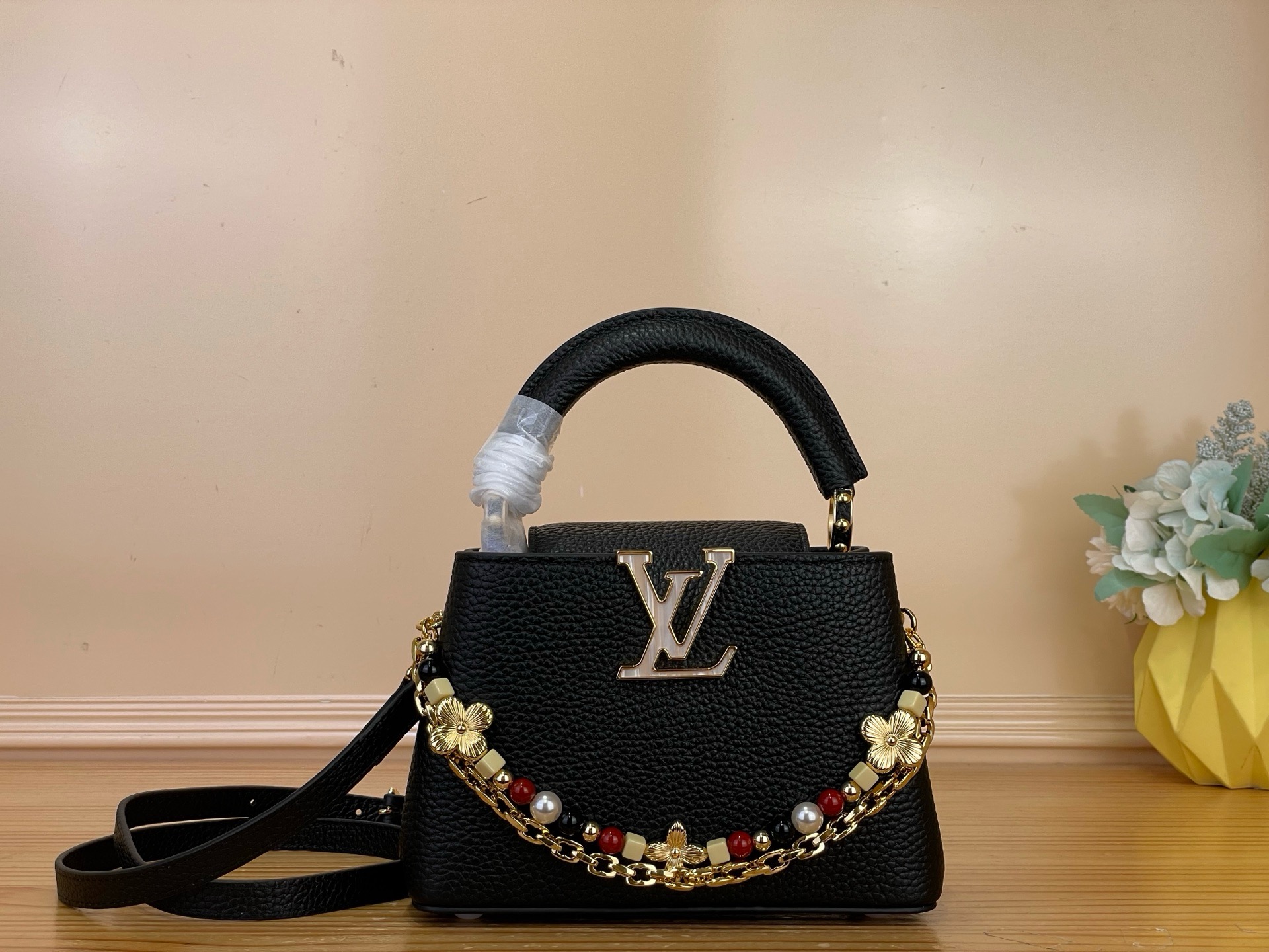 NO:879779,Top original item [CAUCINES BB handbag] M28455 black/floral double chain This Sunbeam series Caucines BB handbag is exquisite and elegant. It is made of grained Taurillon leather and decorated with decorative chains. One chain is equipped with hand-assembled links, just like fine jewelry; the other is decorated with glass beads and metallic Monogram Hl flowers, shining with charming luster. Embellished with the iconic LV  Letters, various carrying methods, inner compartments can store valuables in an orderly manner. This series of masterpieces comes with exclusive packaging, imbued with the charming style of the Côte d'Azur. It comes with limited charms and the brand's iconic beach hut handbag, allowing you to enjoy the leisurely fun of midsummer - limited edition, subject to availability. Dimensions 13.6x21x8 cm 118121350 (length x height x width),, louis vuitton19860909顶级原单【CAUCINES BB 手袋】 M28455 黑色/花卉双链条 本款 Sunbeam 系列 Caucines BB 手袋精致典雅.选用粒面 Taurillon 皮革制成,缀以装饰链条一条搭配手工组装的链环,宛若精美珠宝；另一条饰有玻璃感串珠与金属质感 Monogram Hl花卉,闪耀迷人光泽.点缀标志性 LV 字母,背携方式多样,内隔层可有序收纳贵重物品. 本系列臻作搭配专属包装,浸染蔚蓝海岸的迷人风情,随附限定挂饰与品牌标志性海滩小屋手袋,尽揽盛夏悠然意趣——限量呈献,售完即止. 尺寸 13.6x21x8厘米 118121350 (长度 x 高 x 宽),,louis vuitton,Bag