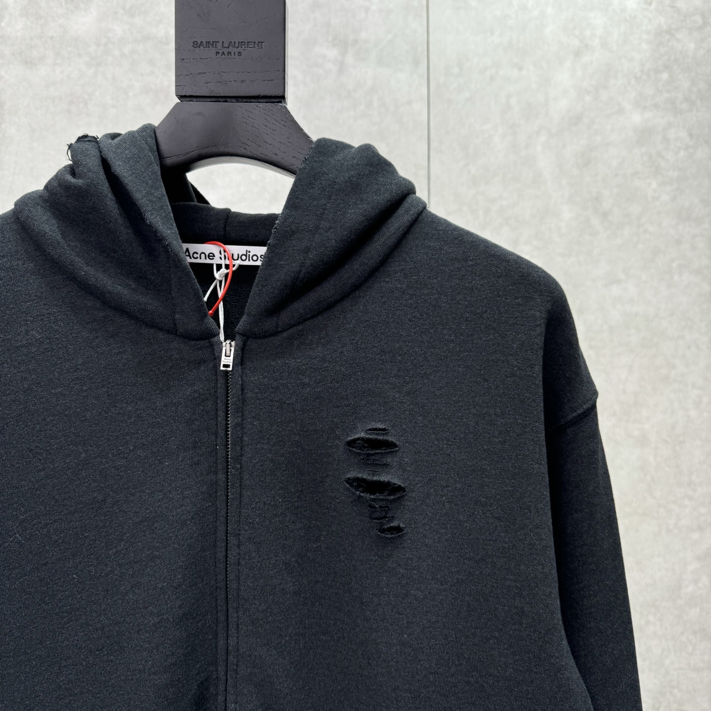 Acne Studios 破洞做旧徽标拉链外套
SIZE S/M/L/XL 💰p325

定制定染1:1墨韵臻柔棉彩棉卫衣料 【面布与毛圈底呈同色配置 （市场面料现货处面底异色 不符合原版） 面料起订量为2吨 单纯面料制造环节耗时45天】云感般的触感 细腻柔软 舒适贴肤 以深邃黛黑为主色调 仿若古老铜器上的斑驳锈迹  前幅同质化clean fit呈现 后幅镌刻着AcneStudios不羁的灵魂 破洞元素的巧妙融入 在黛黑画布上肆意挥洒 是刻意为之的叛逆 是对传统束缚的挣脱 在潮流的浪潮中独树一帜
工艺1:  采用胶浆印花 胸前印花经过三次菲林网板修改 使用胶浆液体涂料在织物上打印图案 烘烤织物以固定印刷图案
工艺2:  衣身多处皆由纯人工规律性定位磨破 手工刷痕 在衣物表面增加纹理和深度感 以模仿自然磨损的质感
工艺3:  面料都经过浇洗 手感质感更佳 不易变形 不易缩水 不易褪色 保持长久的美观
